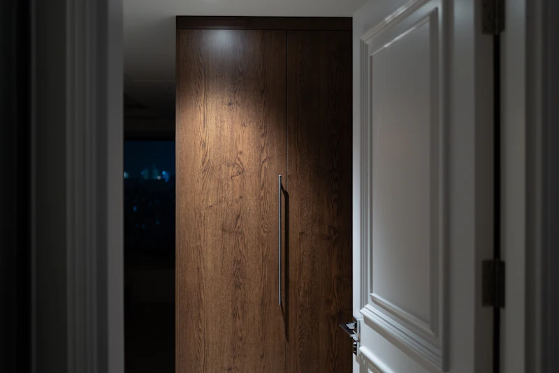 Puerta de madera de diseño iluminada por un foco cenital