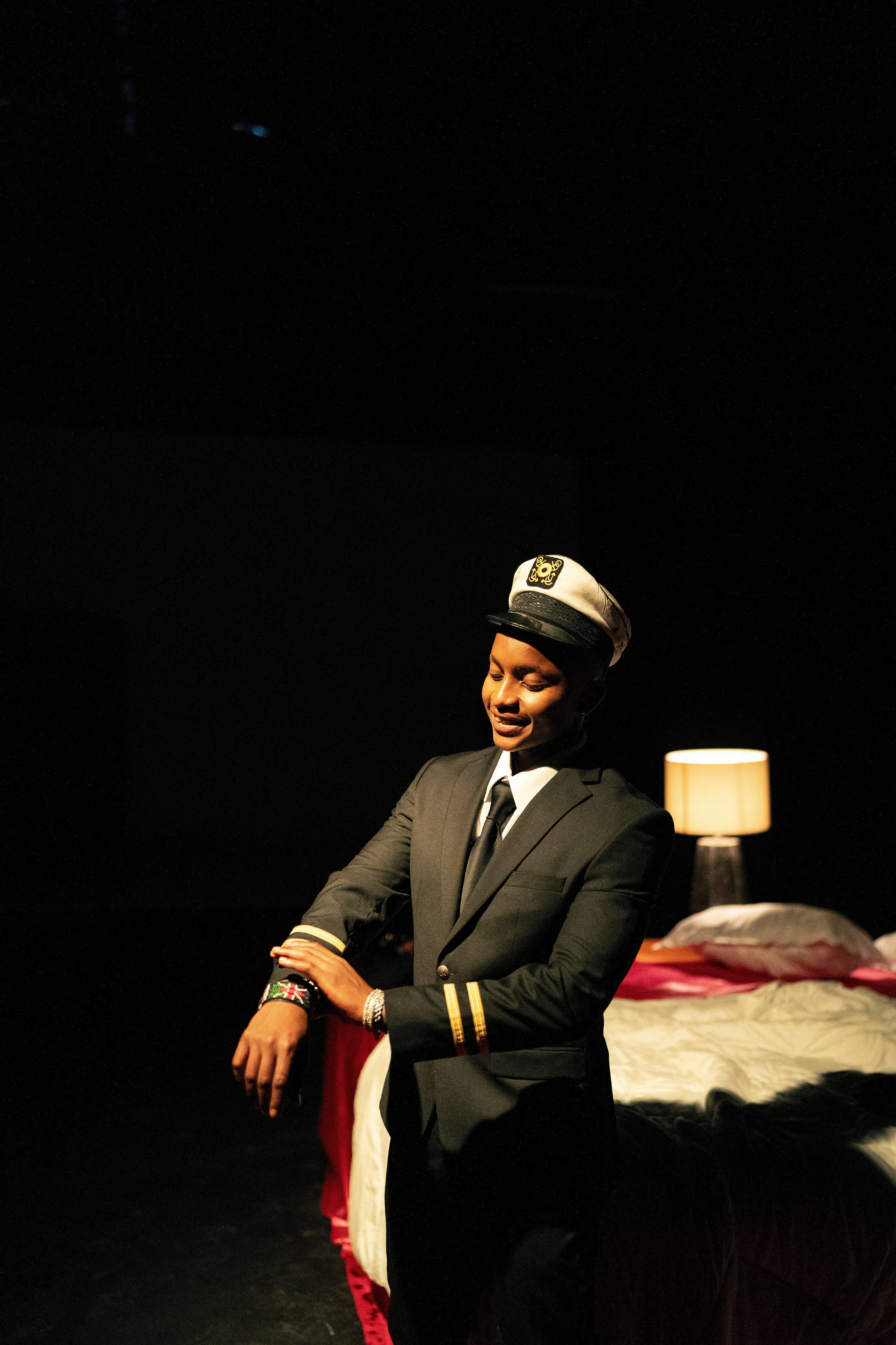 A man in a captain's uniform checks his watch.