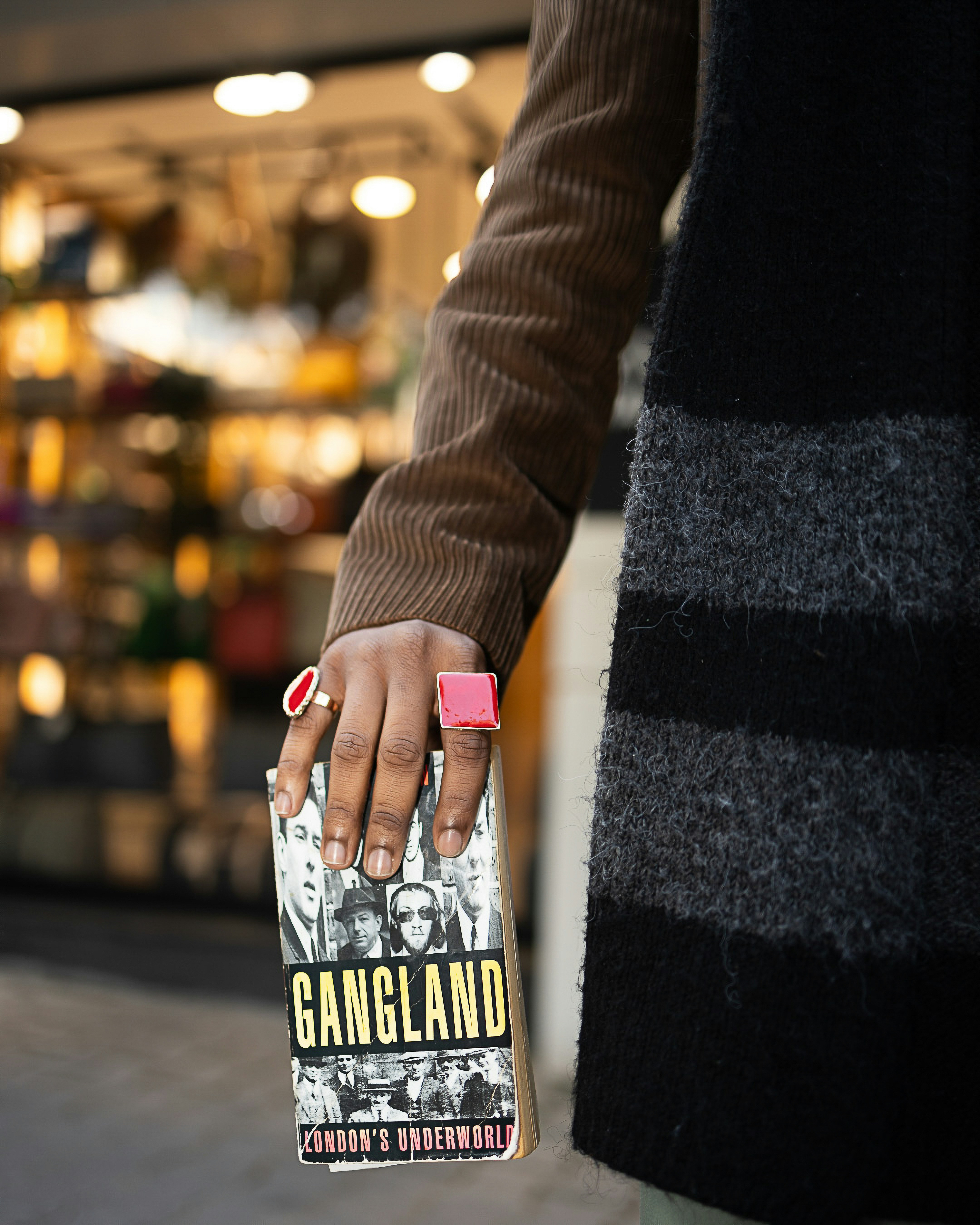 Person holding a book titled gangland