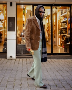 Man in stylish outfit walks down street.
