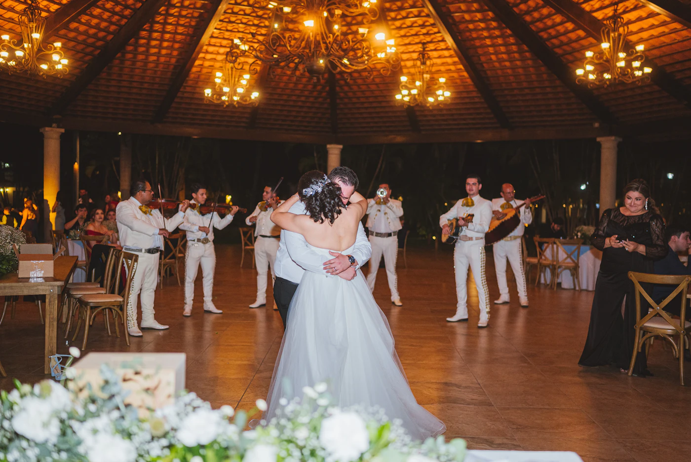Wedding DJ versus live band cost comparison — A five-piece live band performs on stage during a wedding reception.