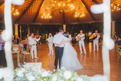 A couple dancing at a wedding reception with a mariachi band playing music