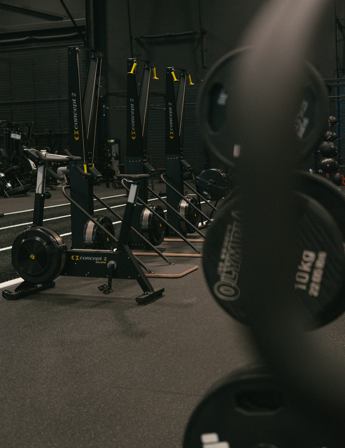 Rowing machines and weight plates inside a modern training facility