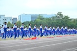Students in blue uniforms perform exercises outdoors