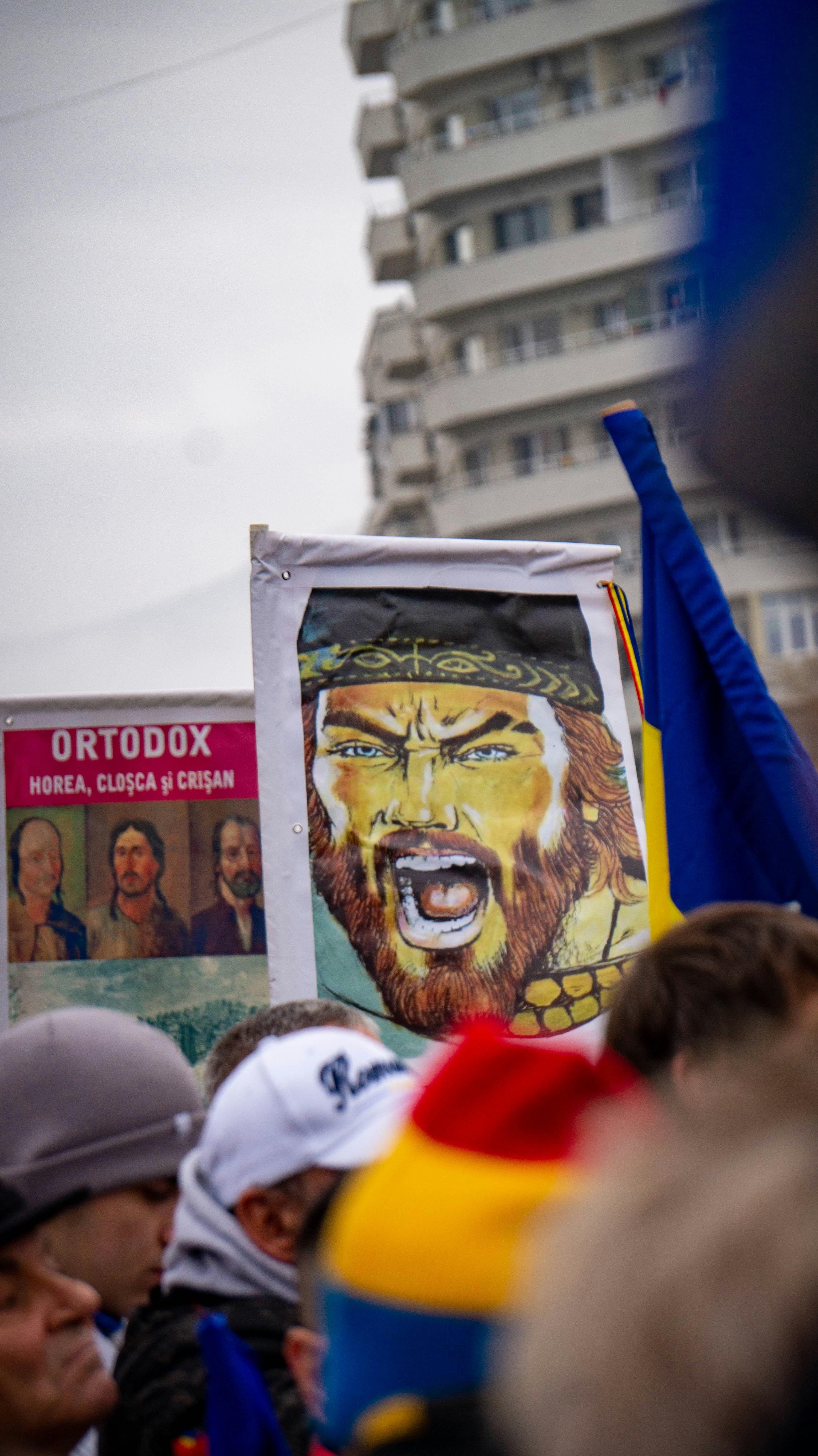 People holding a banner with a man's face