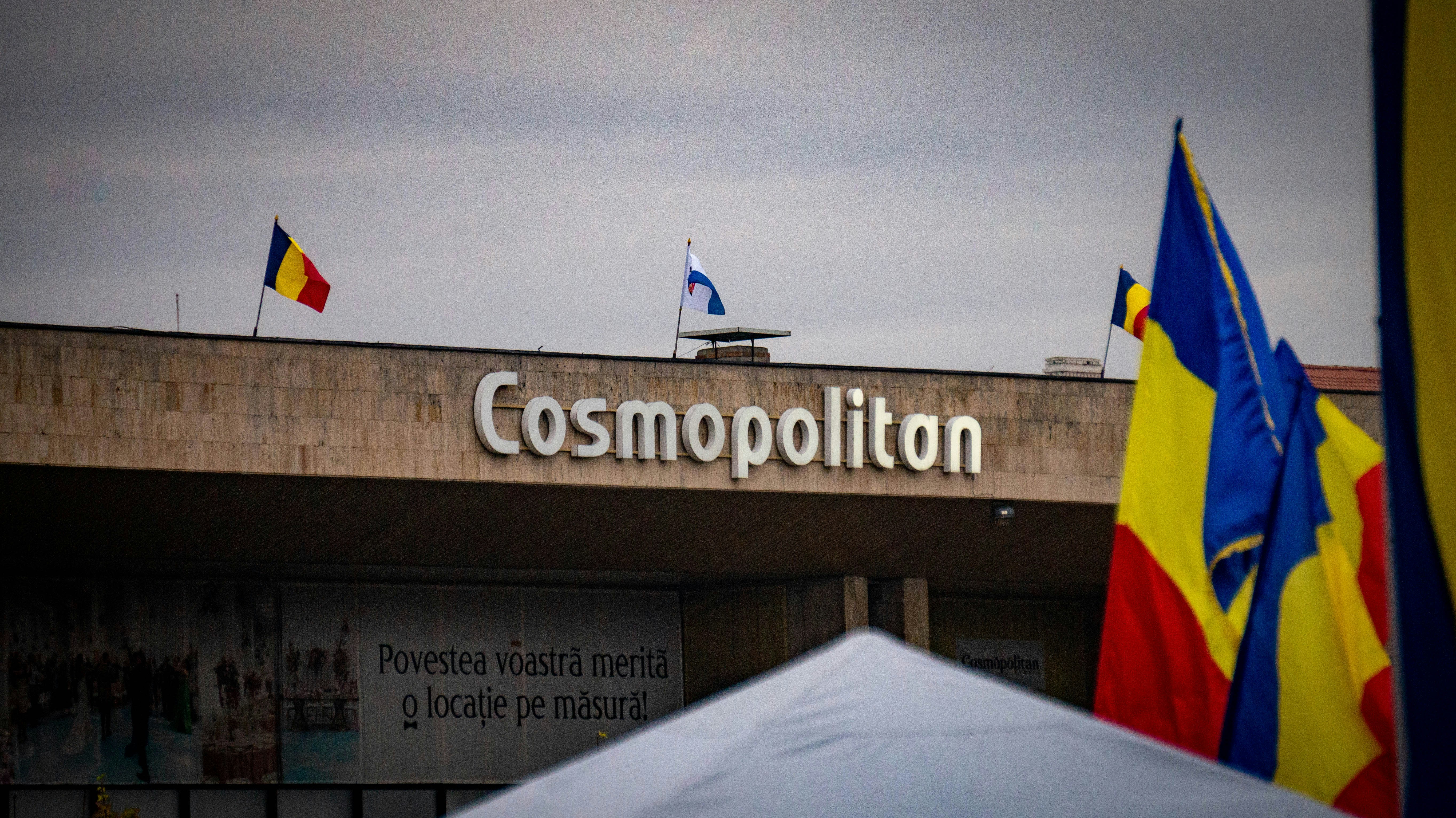 Building with "cosmopolitan" sign and flags