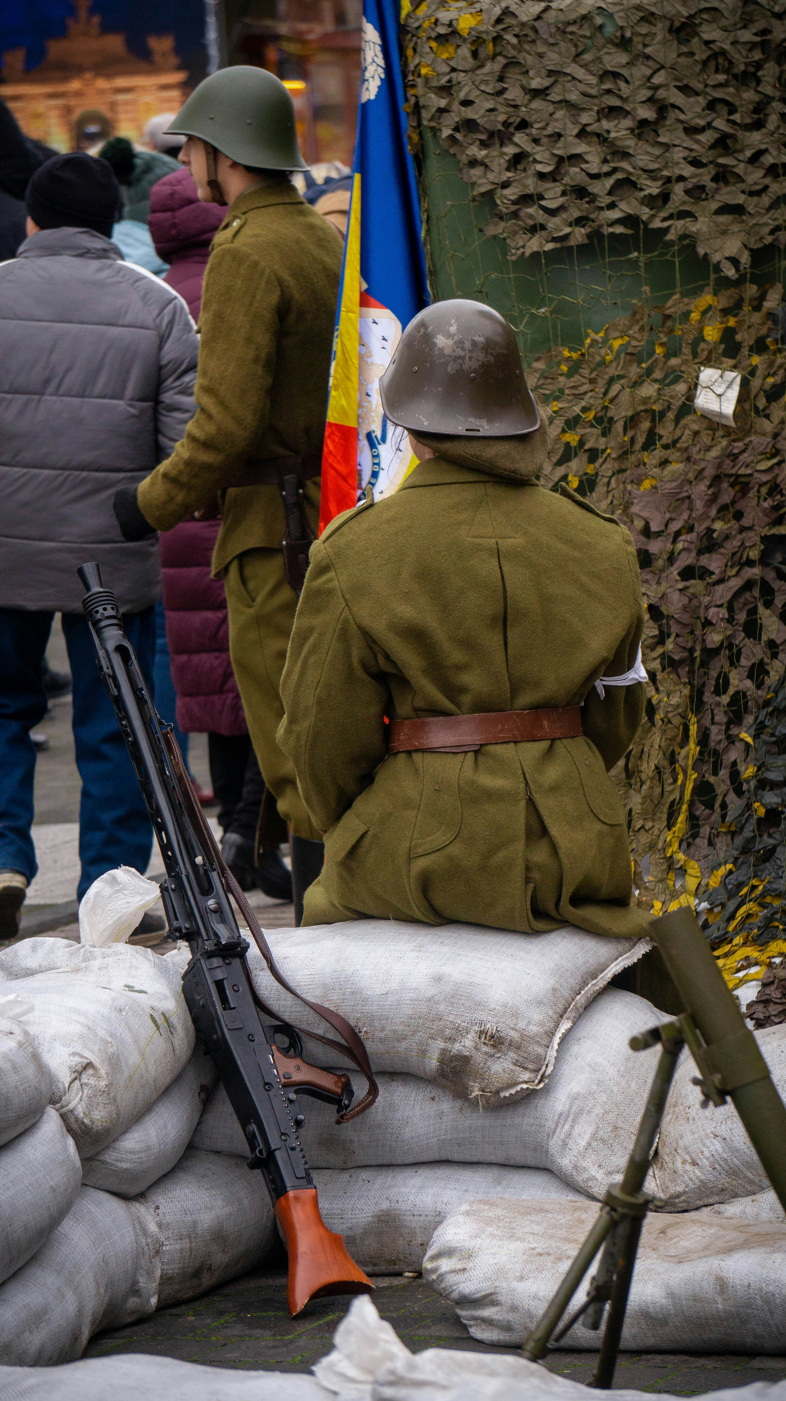 Soldiers in uniform with machine guns and sandbags.