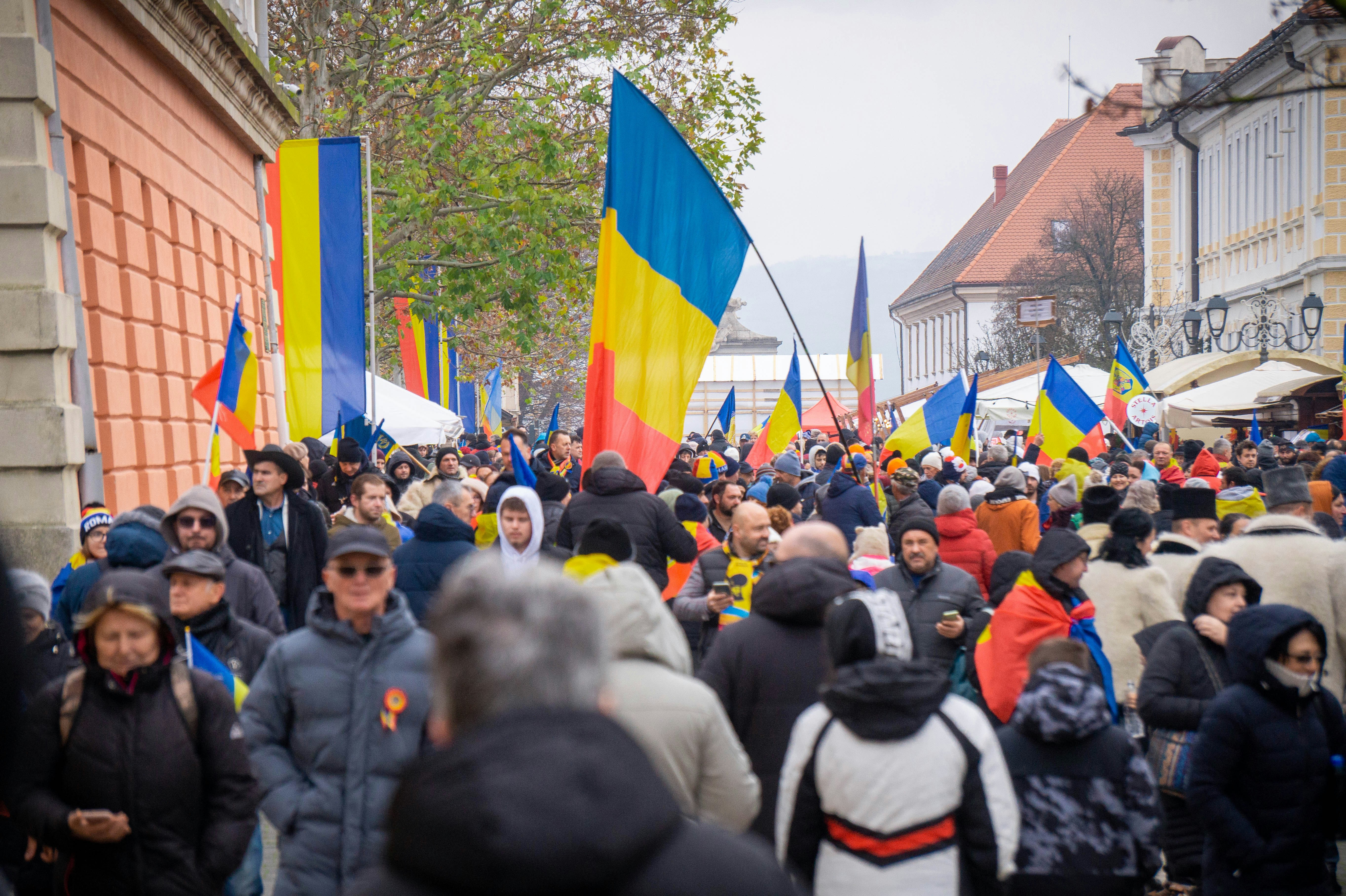 Crowd of people waving romanian flags on a street