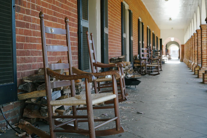 Rocking chairs lined up on a long brick porch