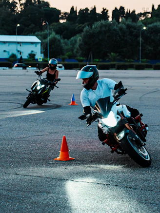 Two motorcyclists practicing on a cone course