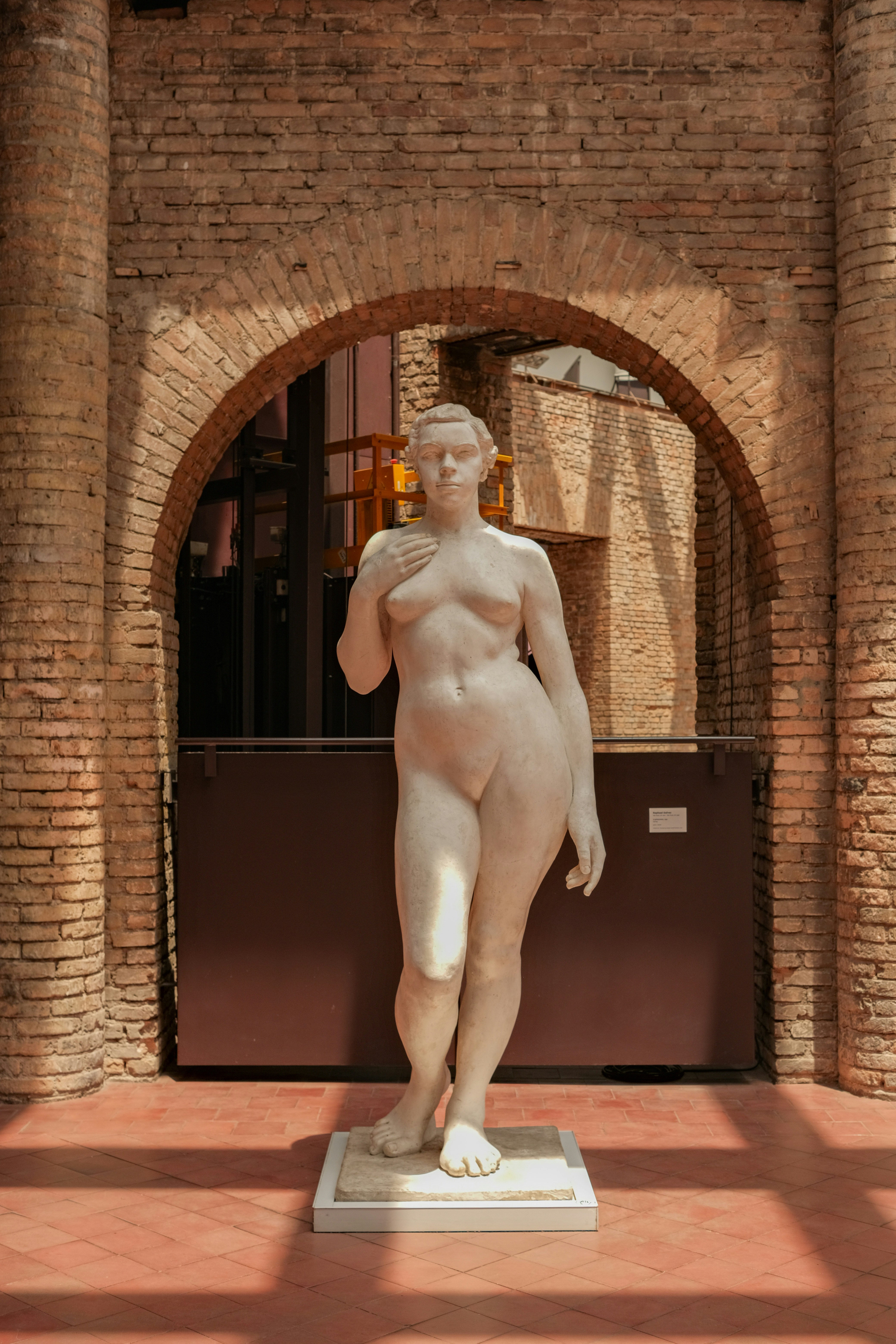 Marble statue of a woman in an arched hallway.