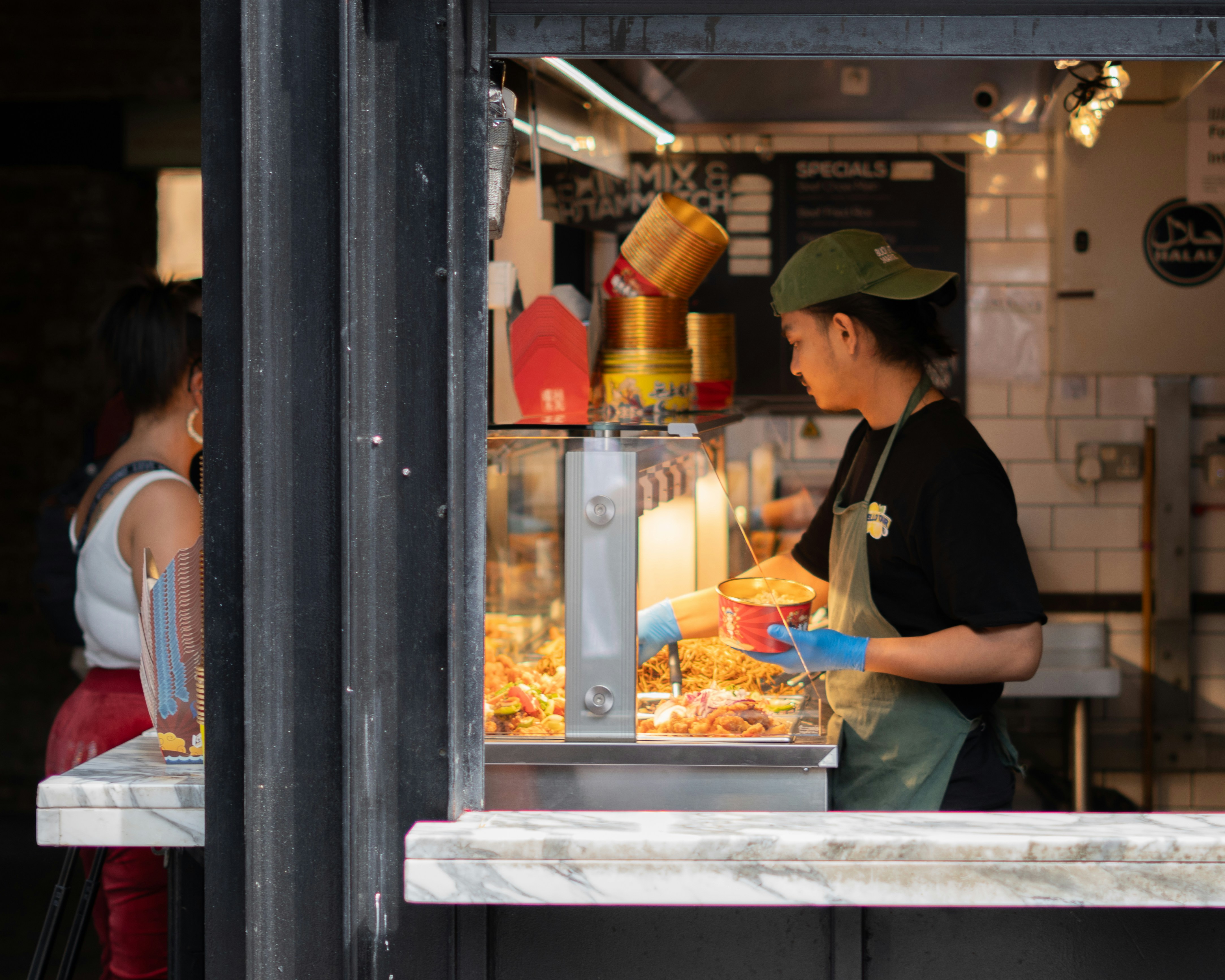 A vendor serves food through a window.