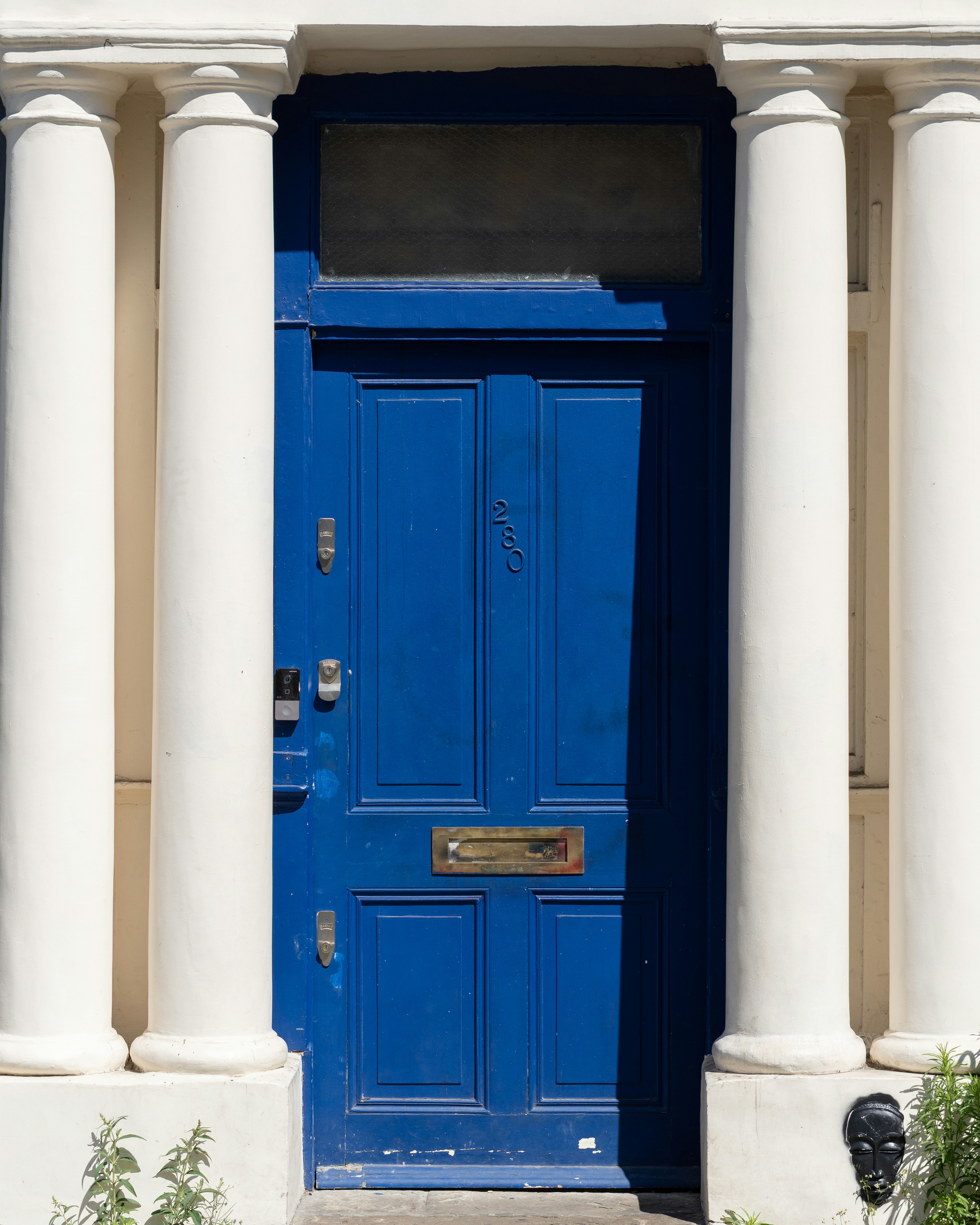 A vibrant blue door framed by white columns.