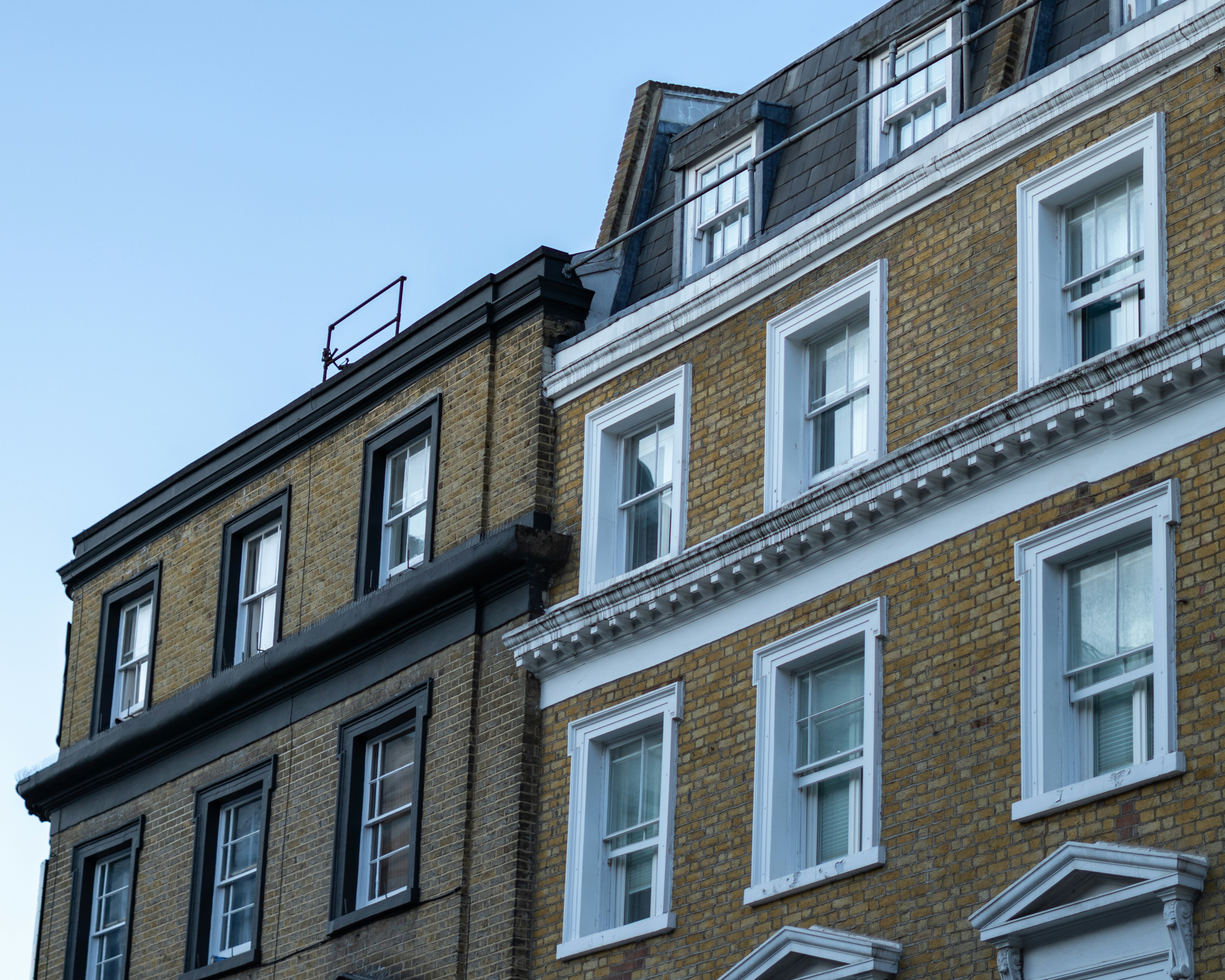 Two brick buildings with many windows under sky