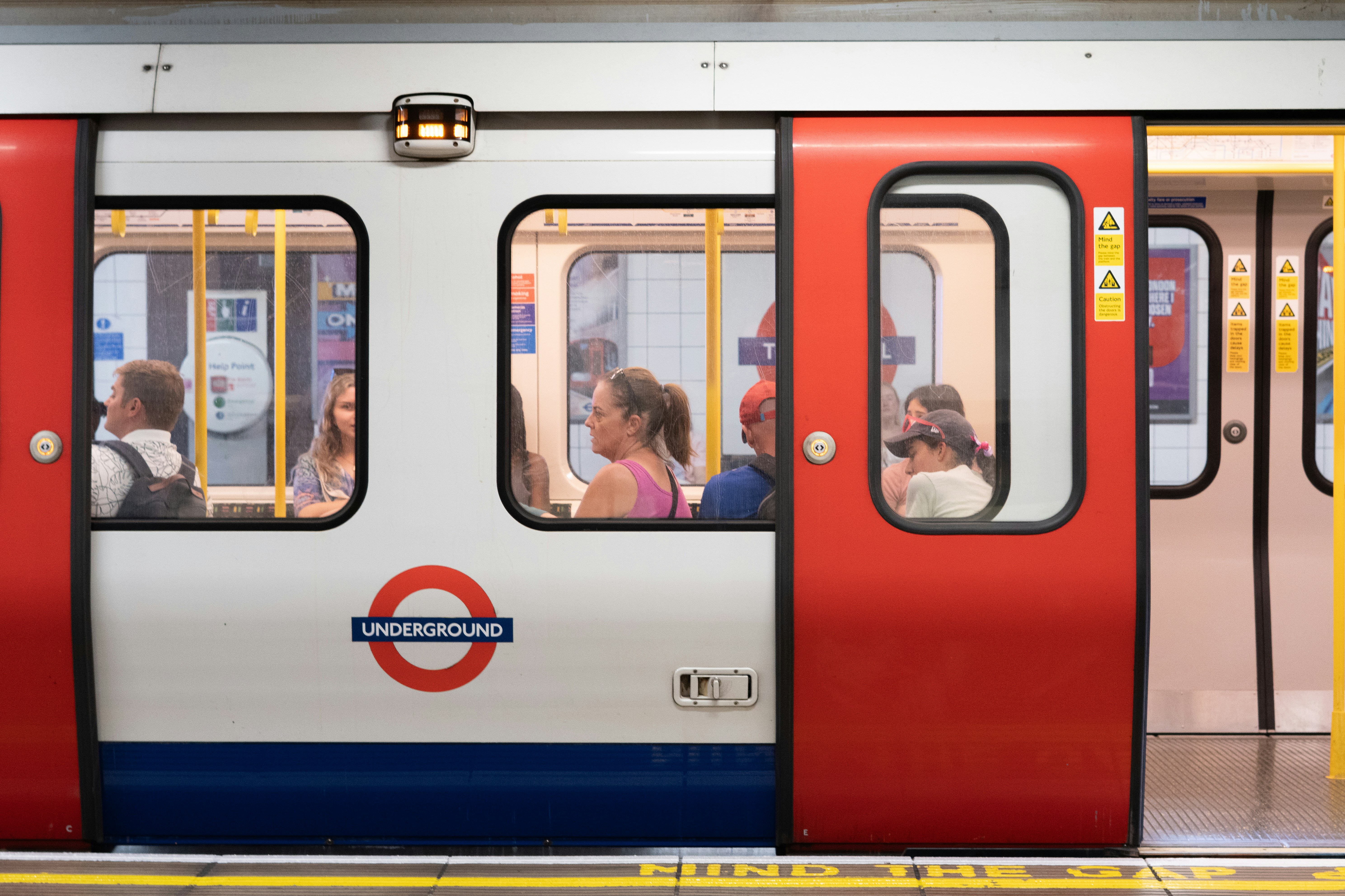 London underground train with open doors and passengers.