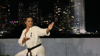 Woman practicing karate in front of city lights