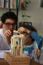 Man and child building with wooden blocks.