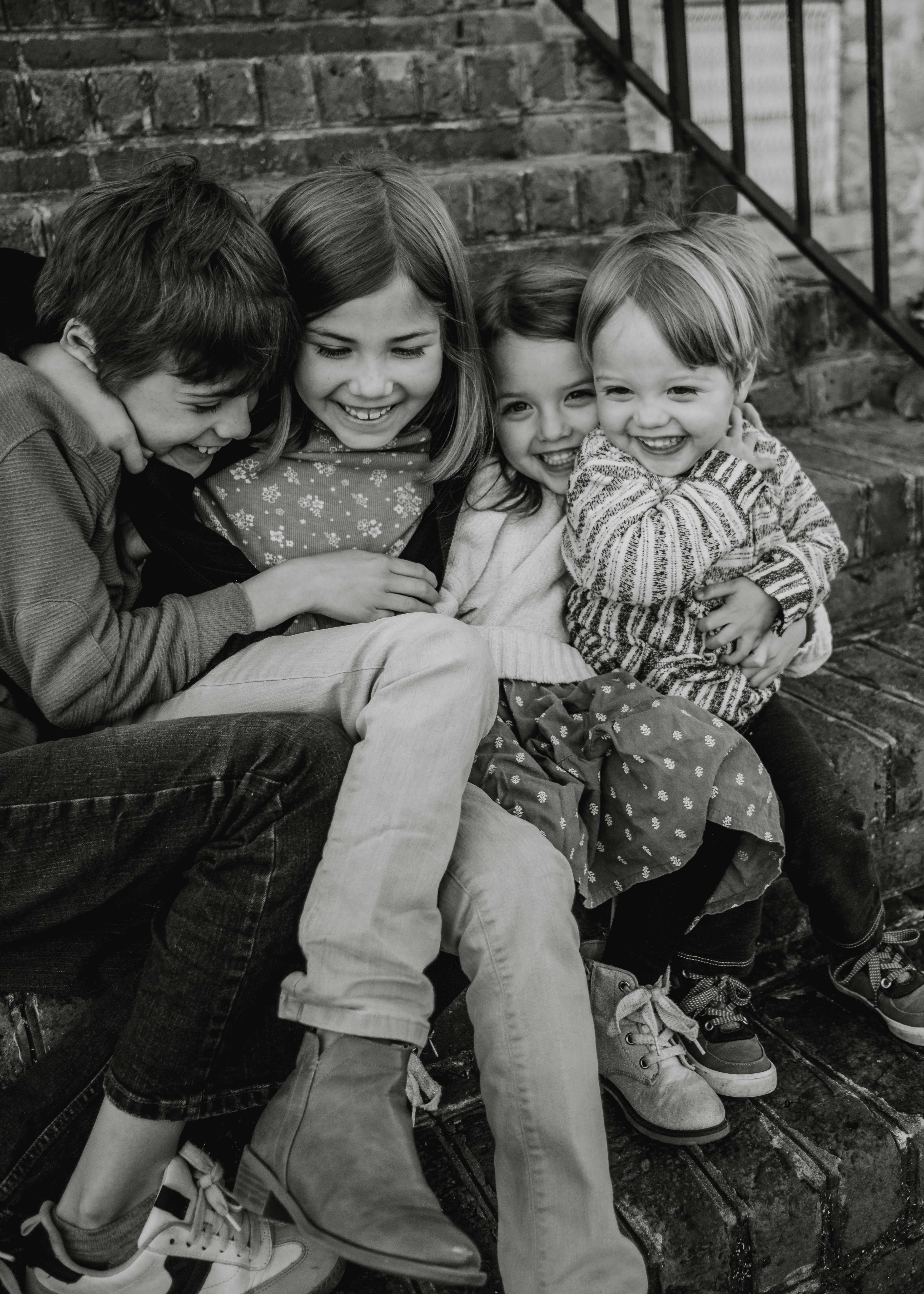 Four children laughing together on steps