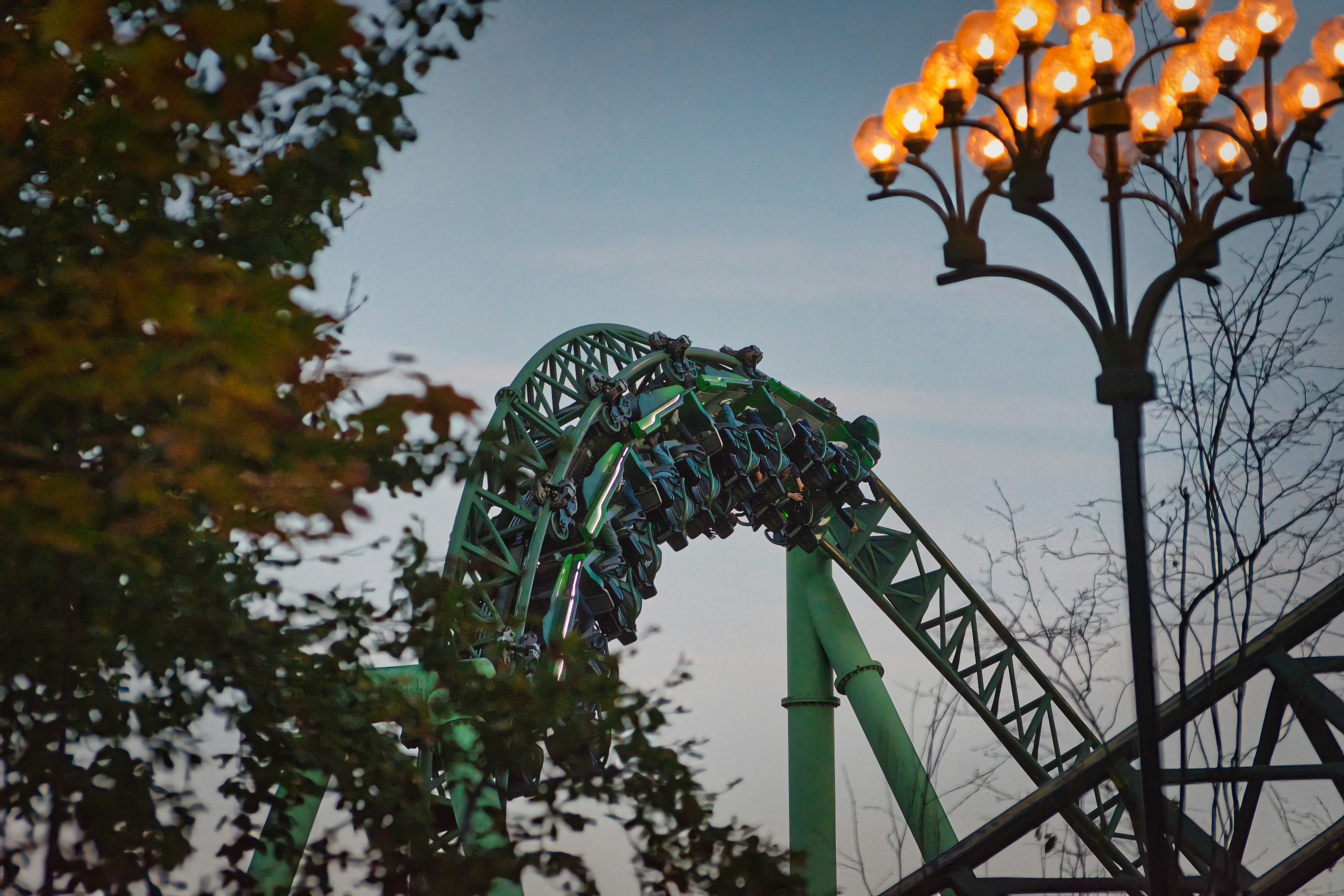 Roller coaster going down a steep drop at night