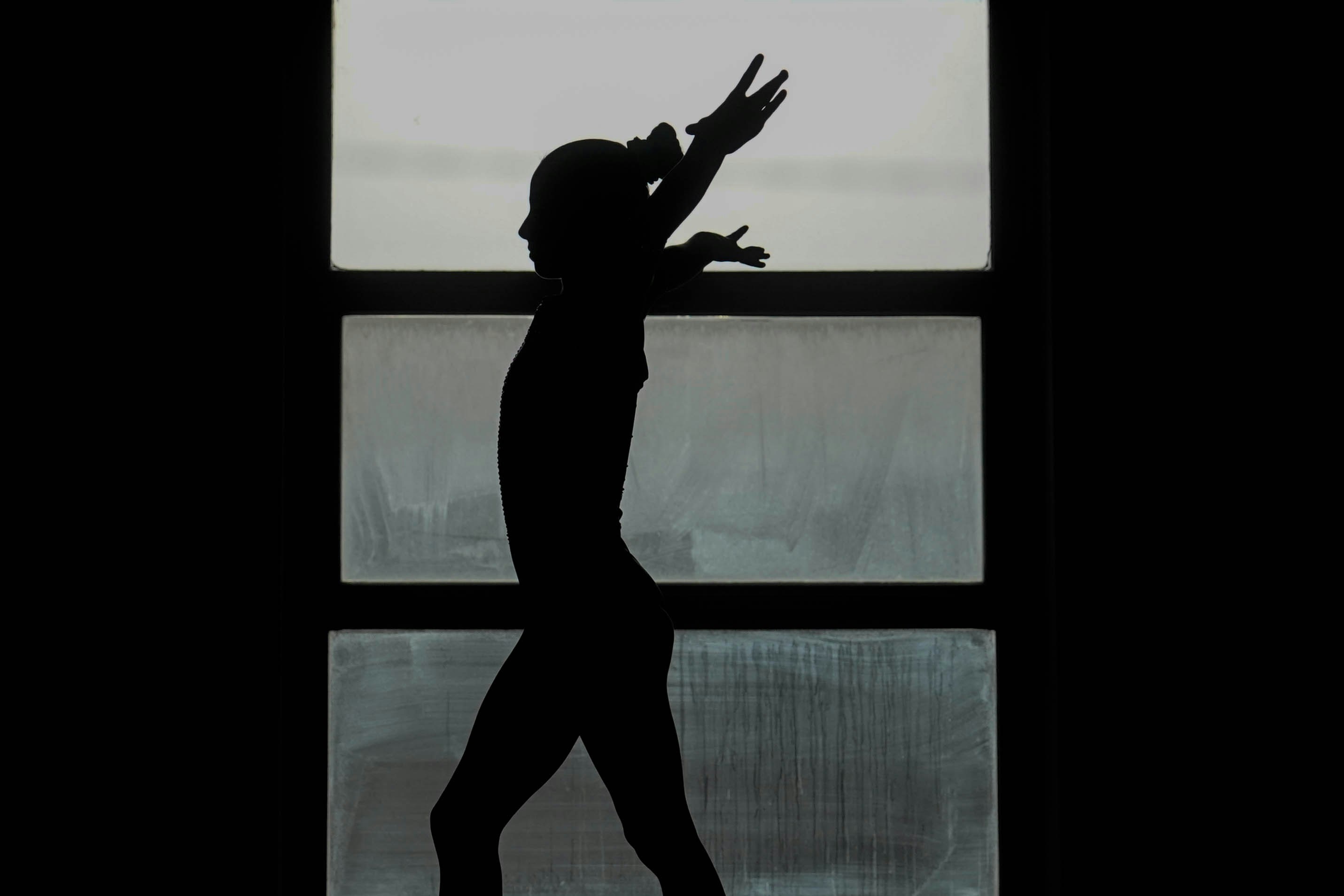 Silhouette of a dancer against a window