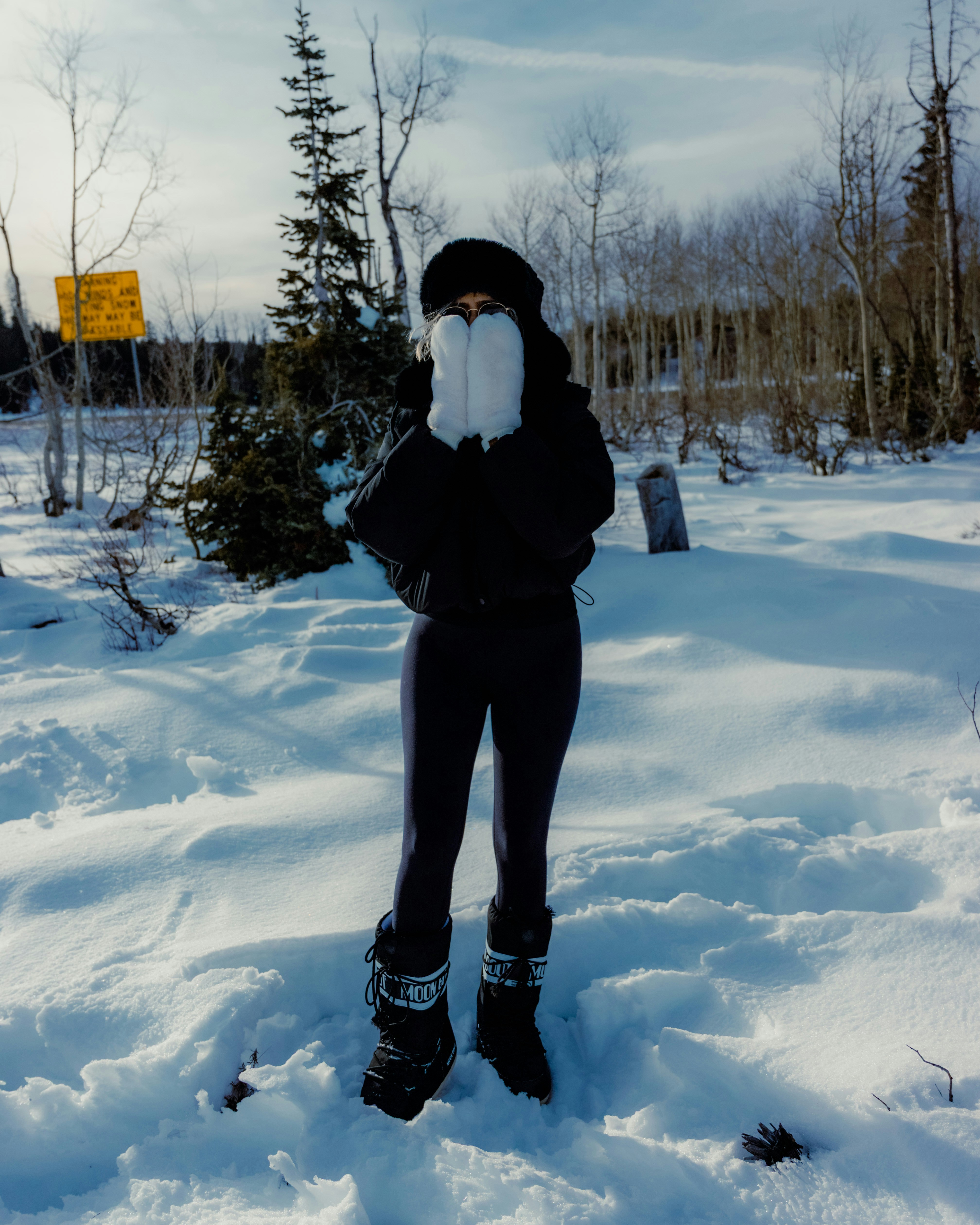 Person in snow with ski boots and fur hat