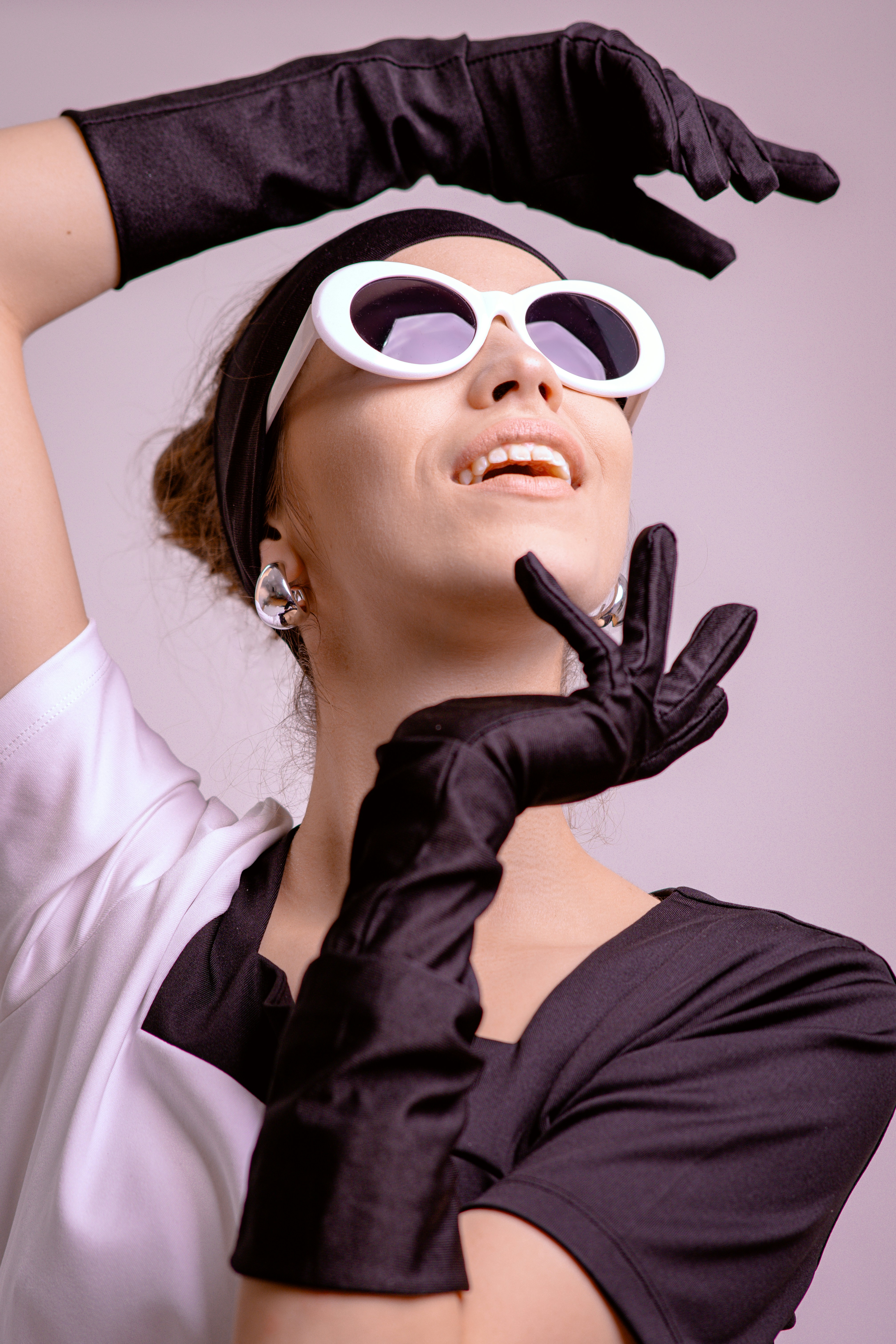 Frau mit weißer Sonnenbrille und schwarzen Handschuhen