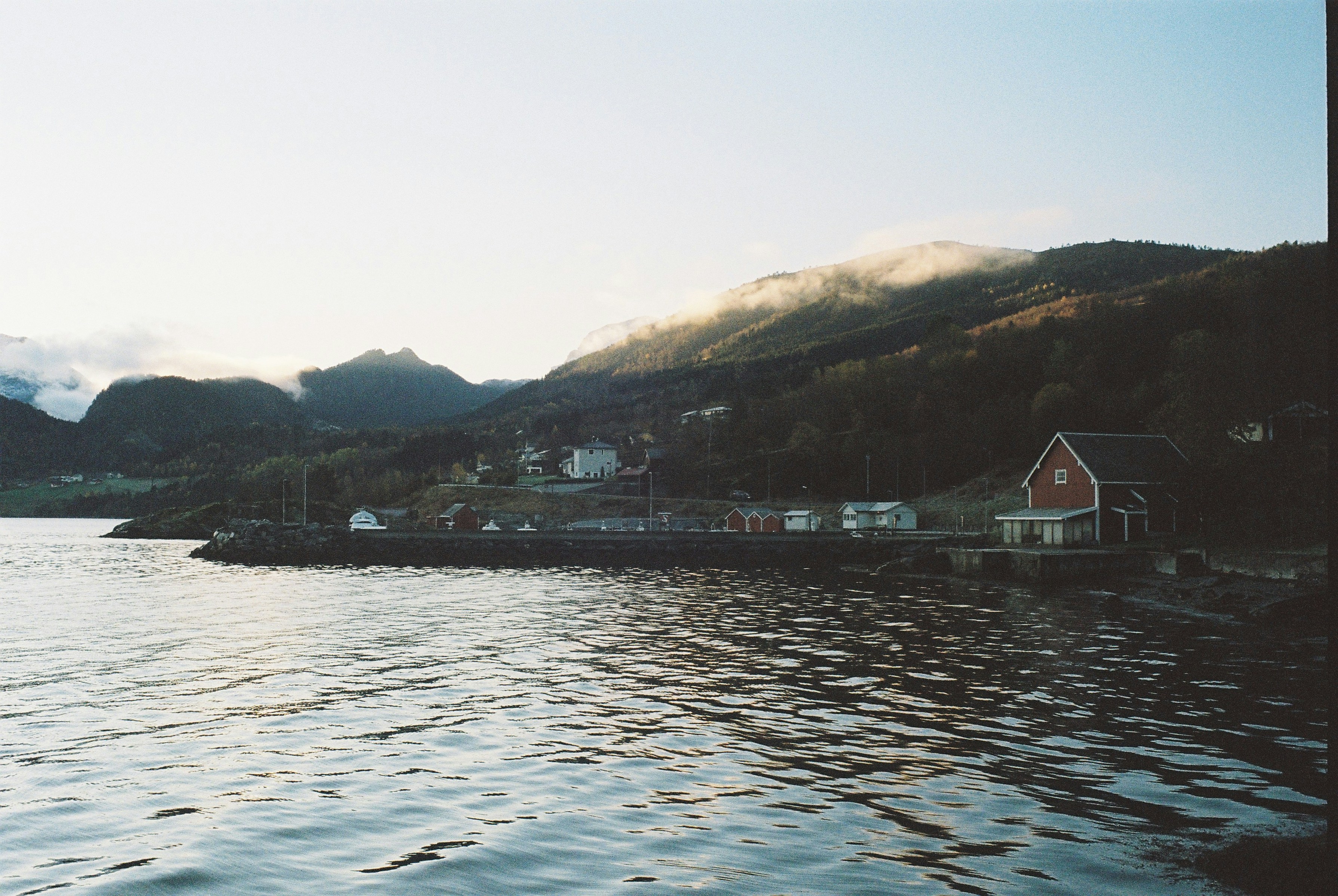Small village on a calm bay with mountains behind