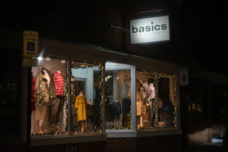 Devanture boutique illuminée la nuit avec mannequins