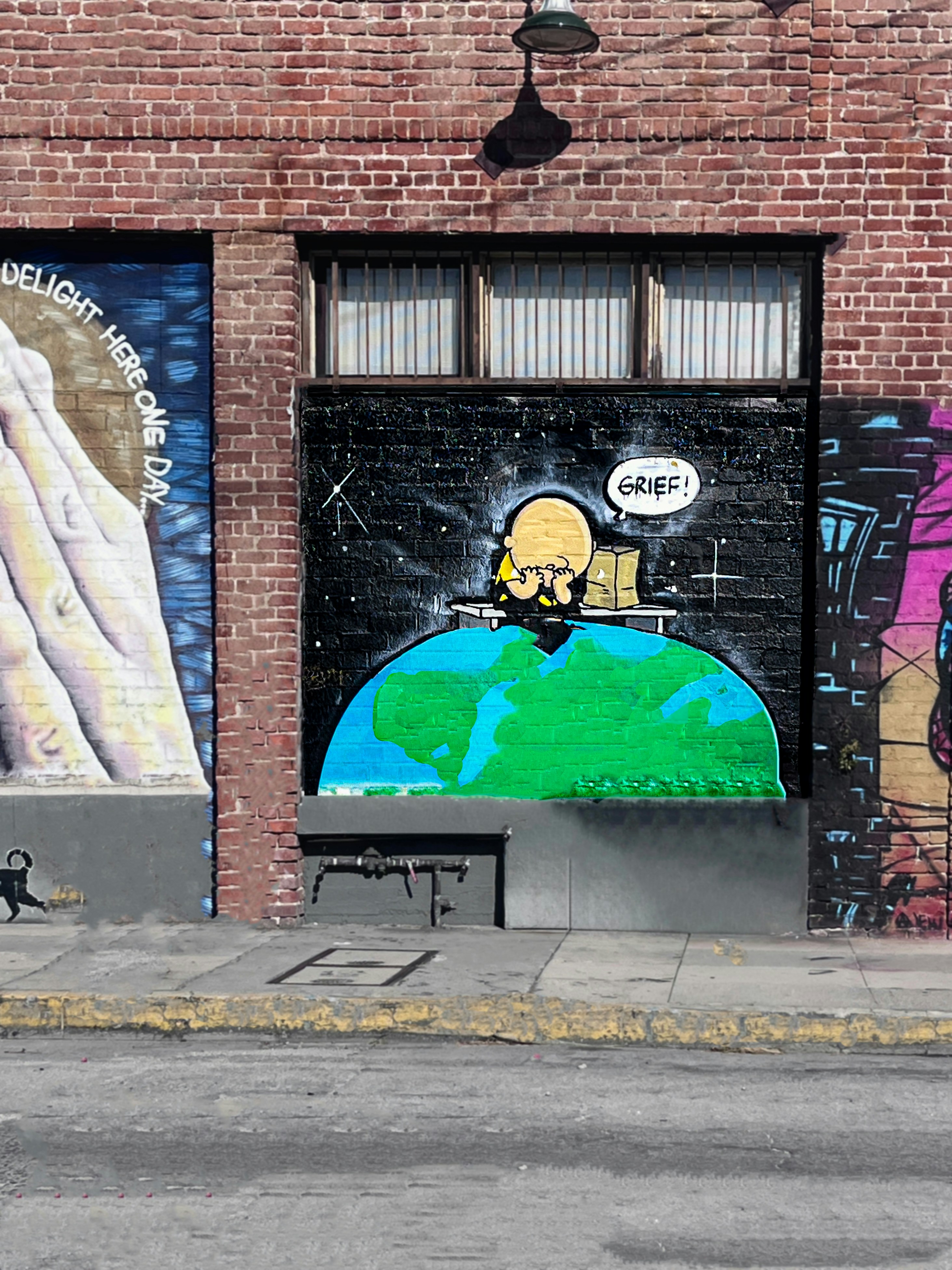 Mural of a person sitting on earth with stars