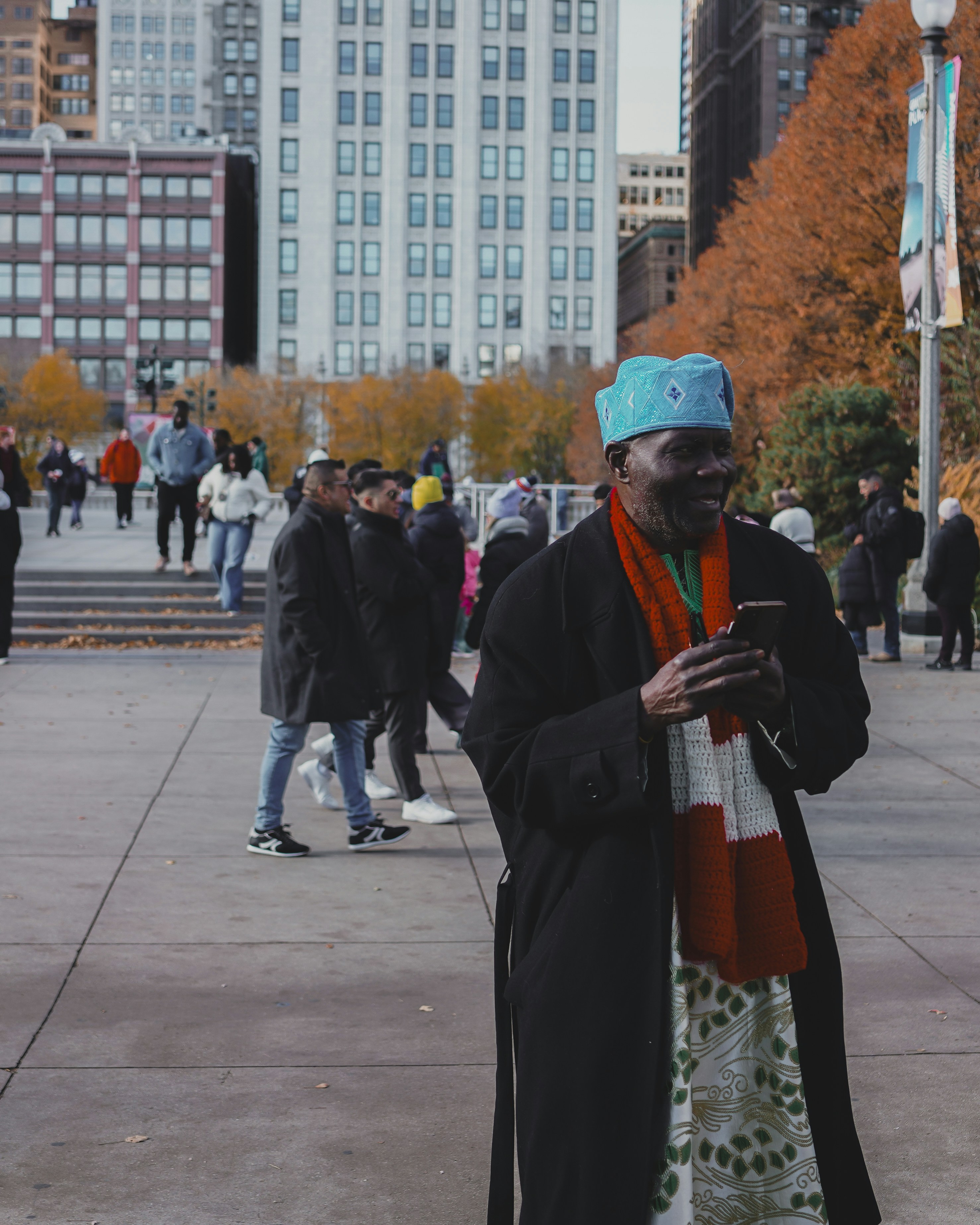 Man in blue hat and scarf using phone outdoors