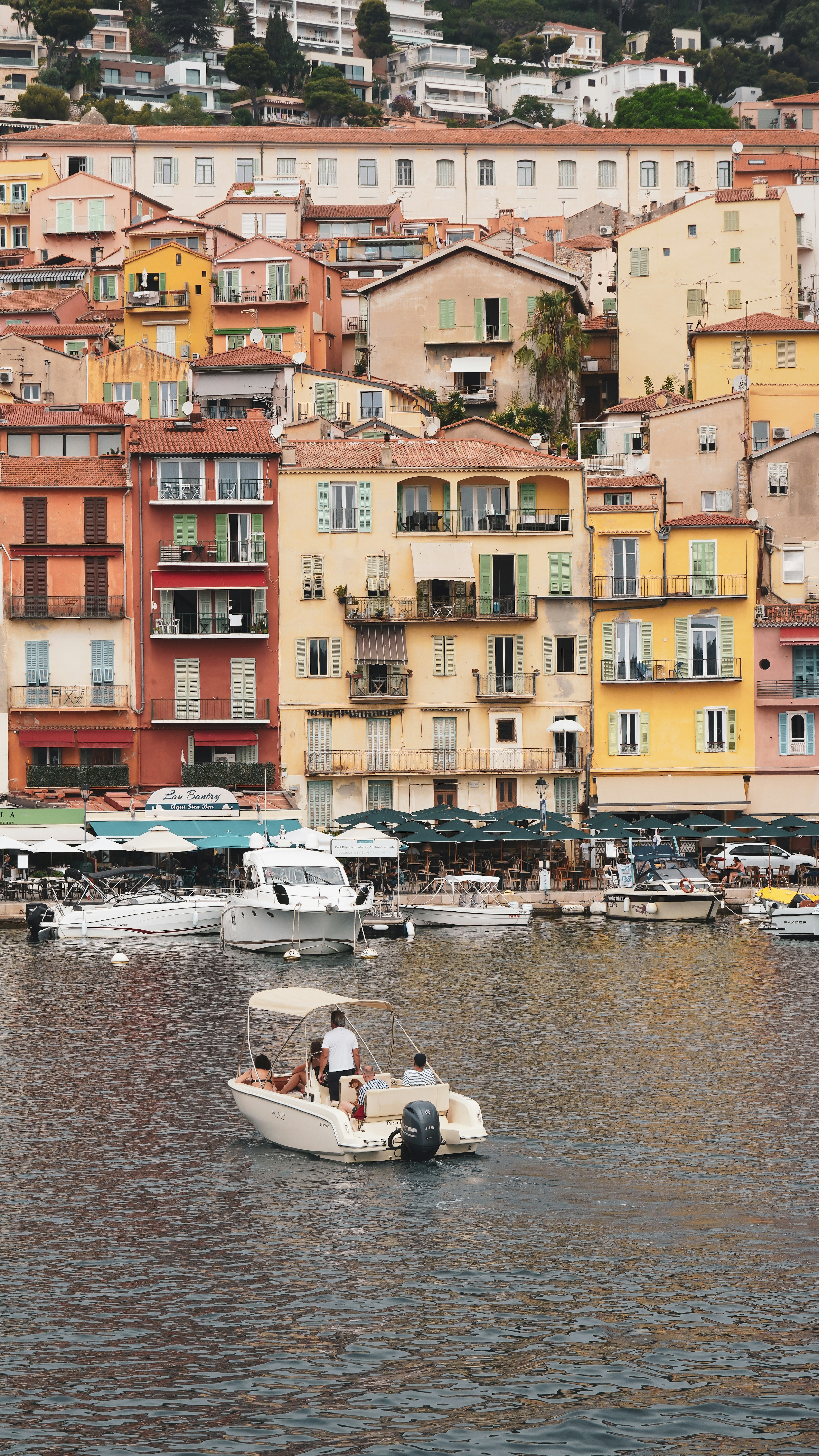 People on a boat in a harbor with colorful buildings.