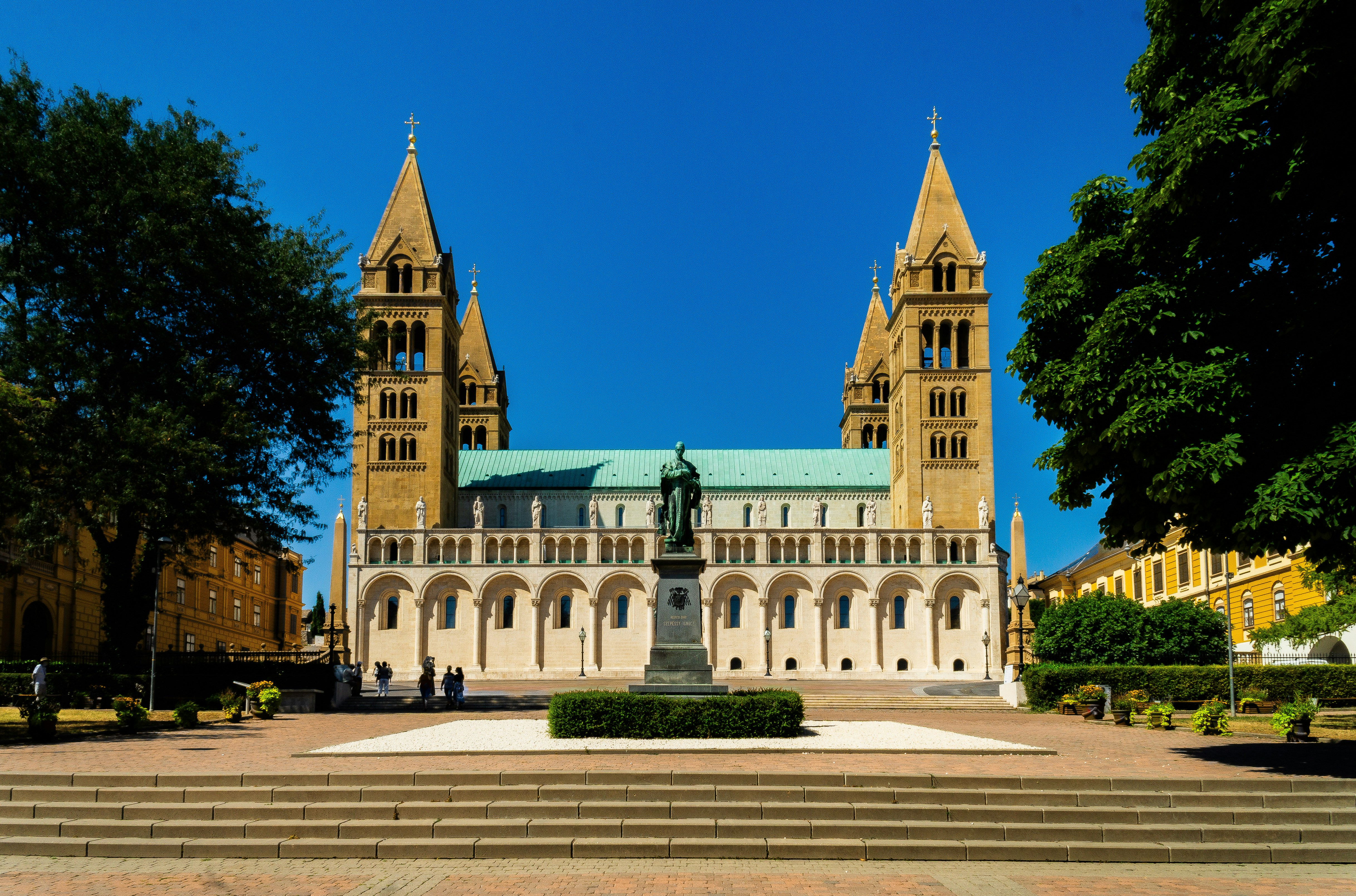 Large cathedral with two towers and a statue.