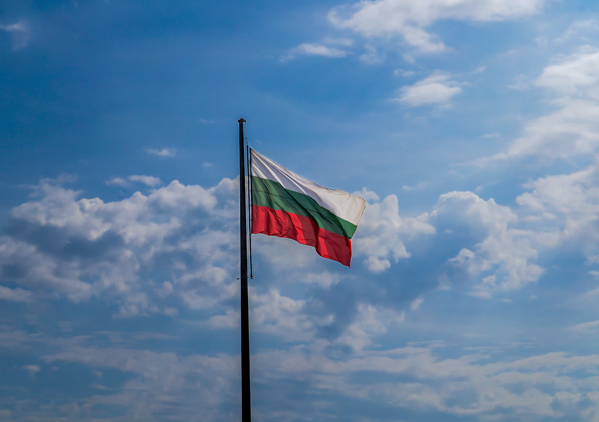 Bulgarian flag waving against a blue sky