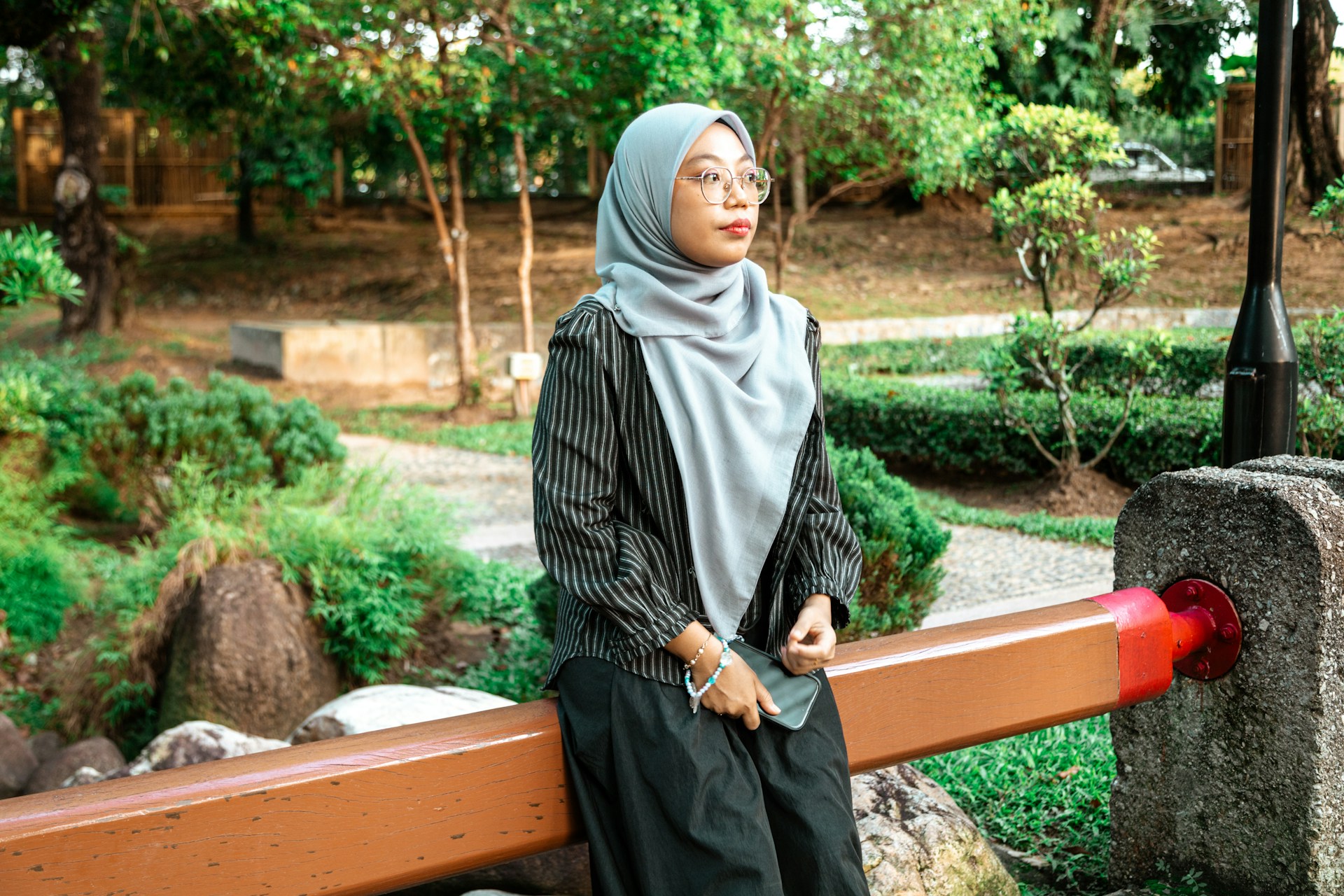 Young woman in hijab sitting outdoors