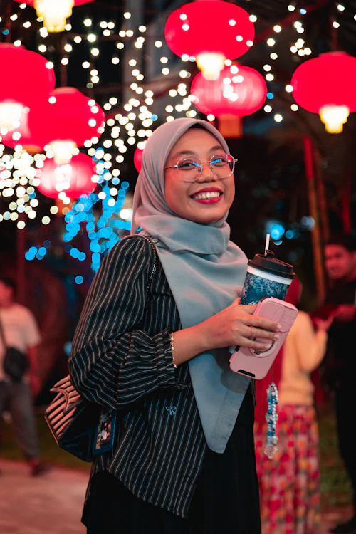A woman in a hijab smiling at her phone