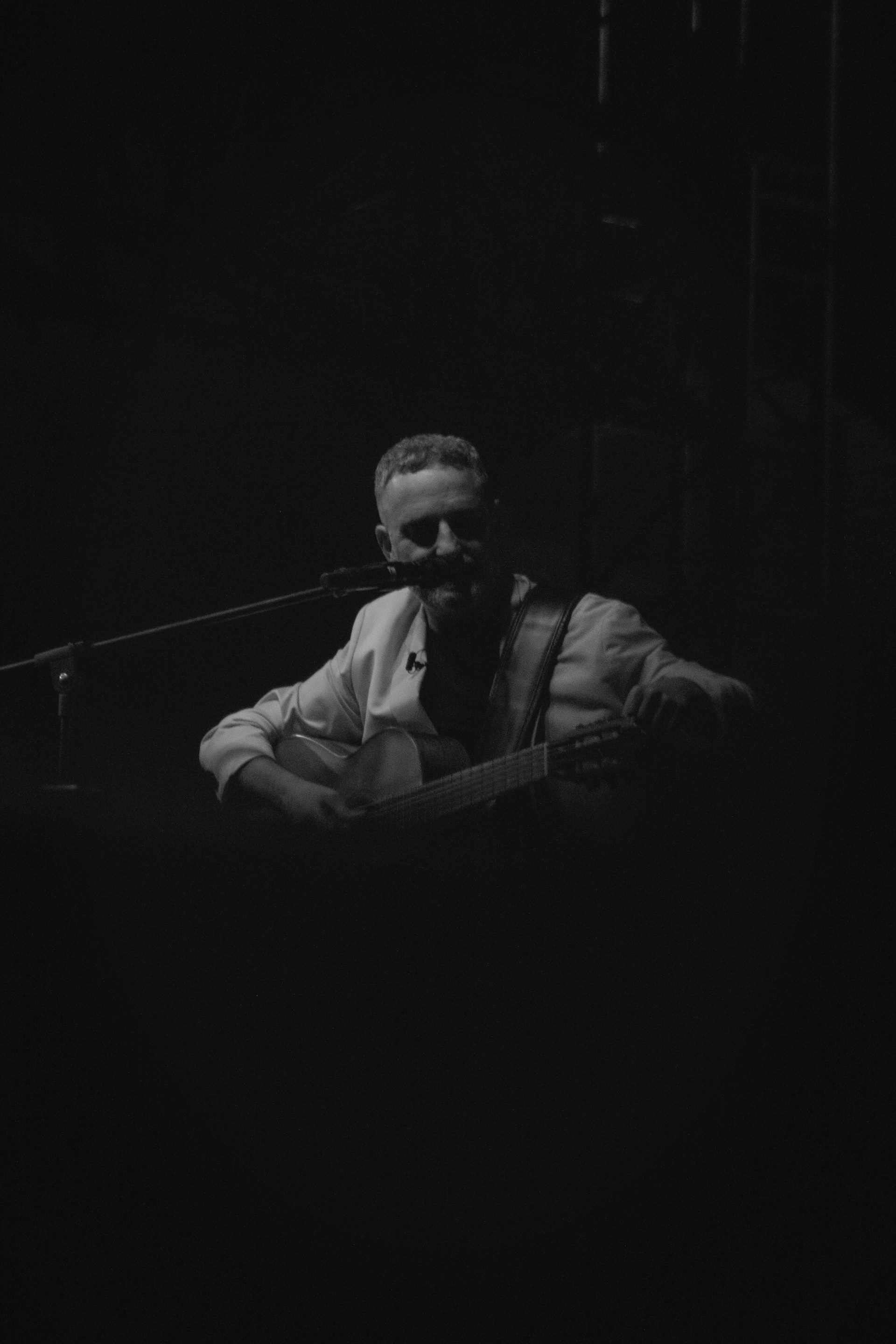 Man playing guitar and harmonica on stage