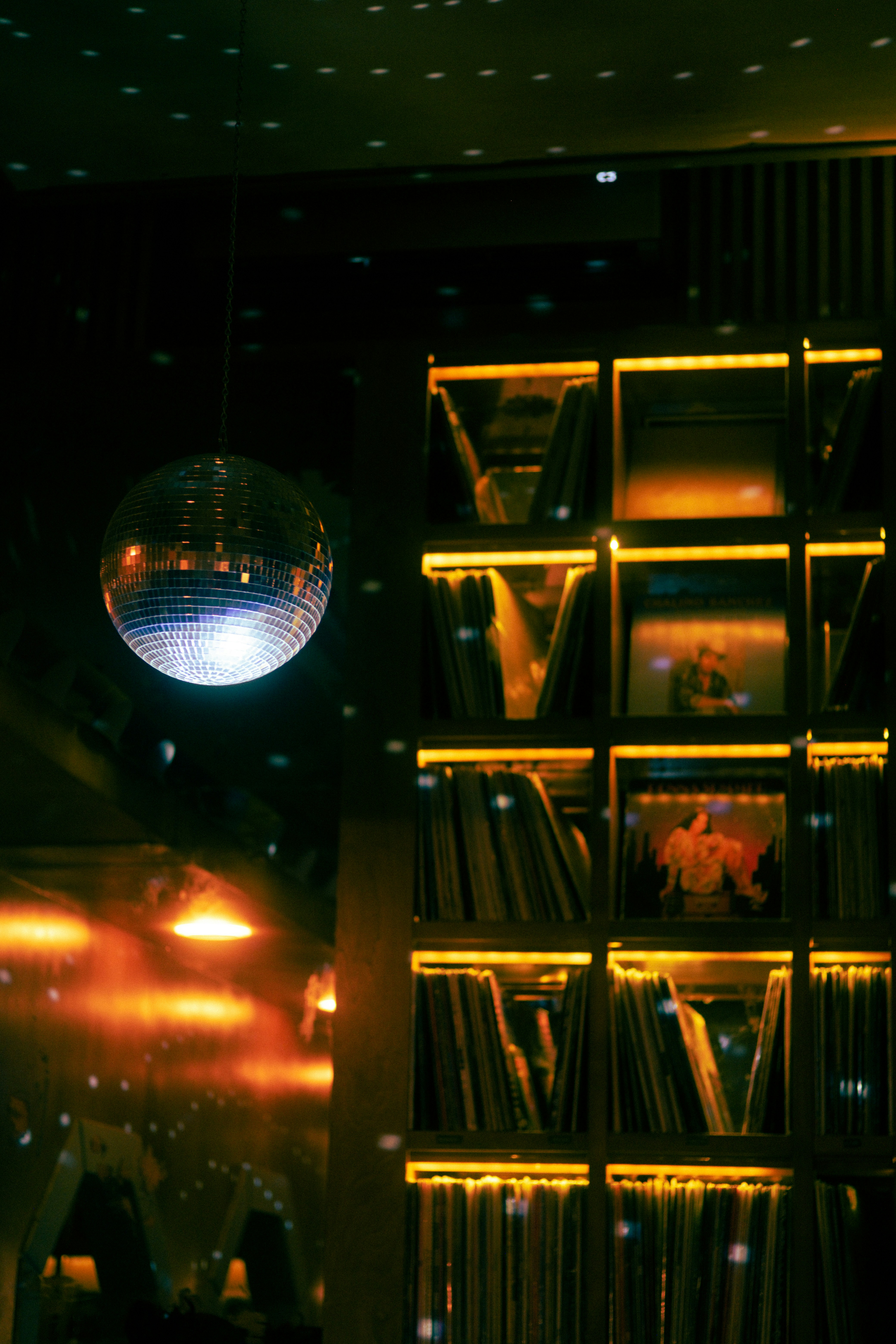 Disco ball and illuminated record shelf at night