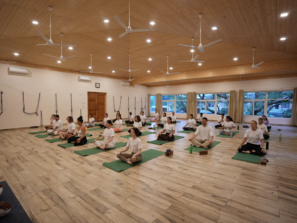 A group resting on mats in a spacious, light-filled room
