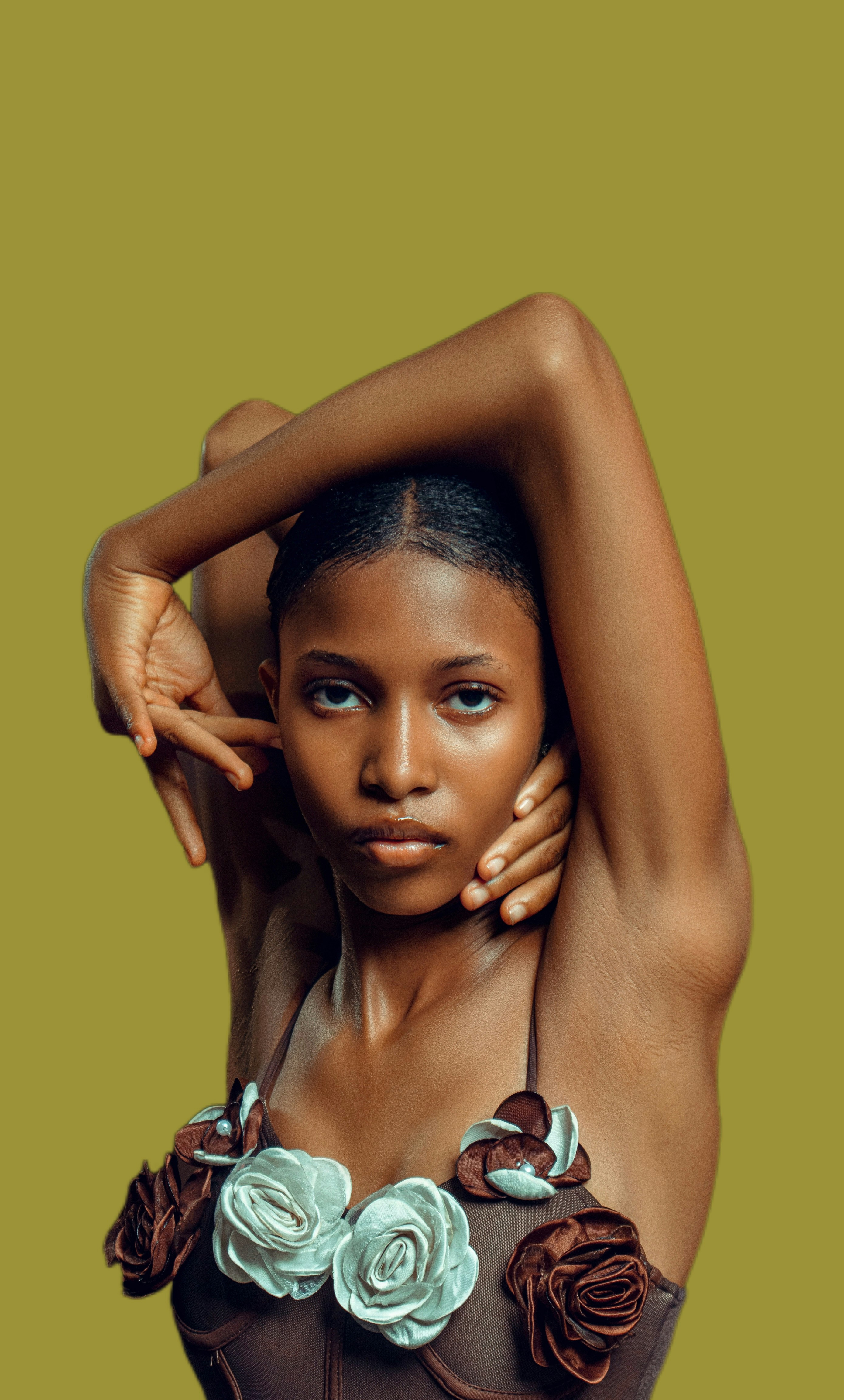 Young woman with arms raised wearing floral-adorned top