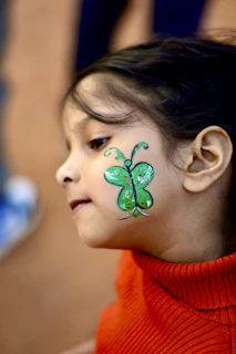 Young girl with green butterfly face paint