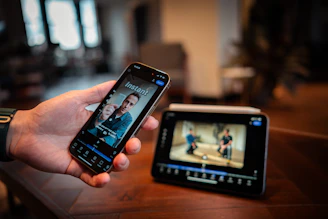 Person holding smartphone showing video content