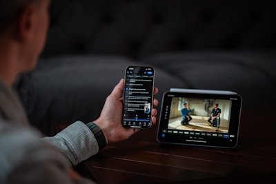 Person holding phone and looking at monitor