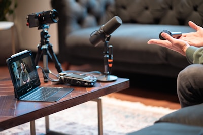 Podcast recording setup with camera, microphone, and laptop