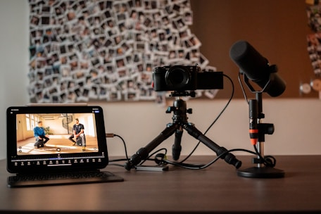 Camera, microphone, and monitor on a desk.