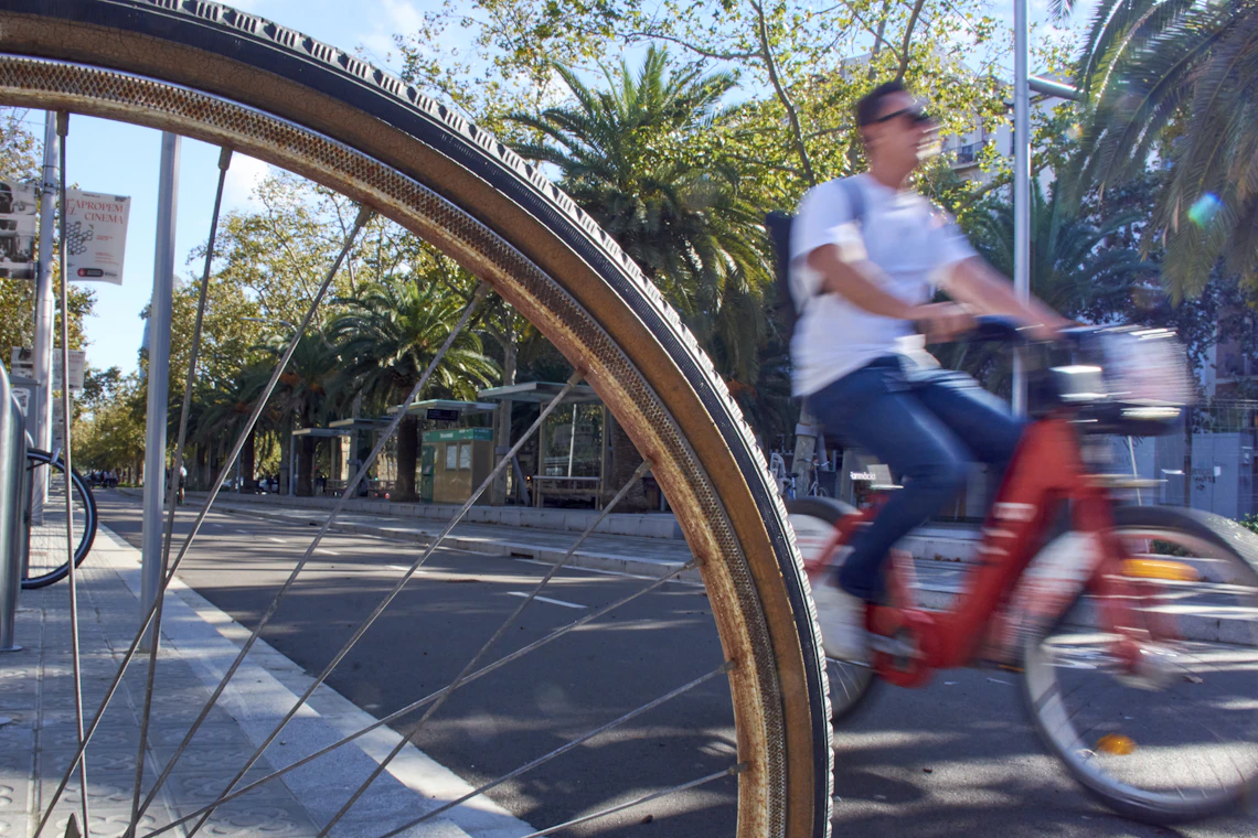 Cyclist passing a bicycle wheel on an urban street