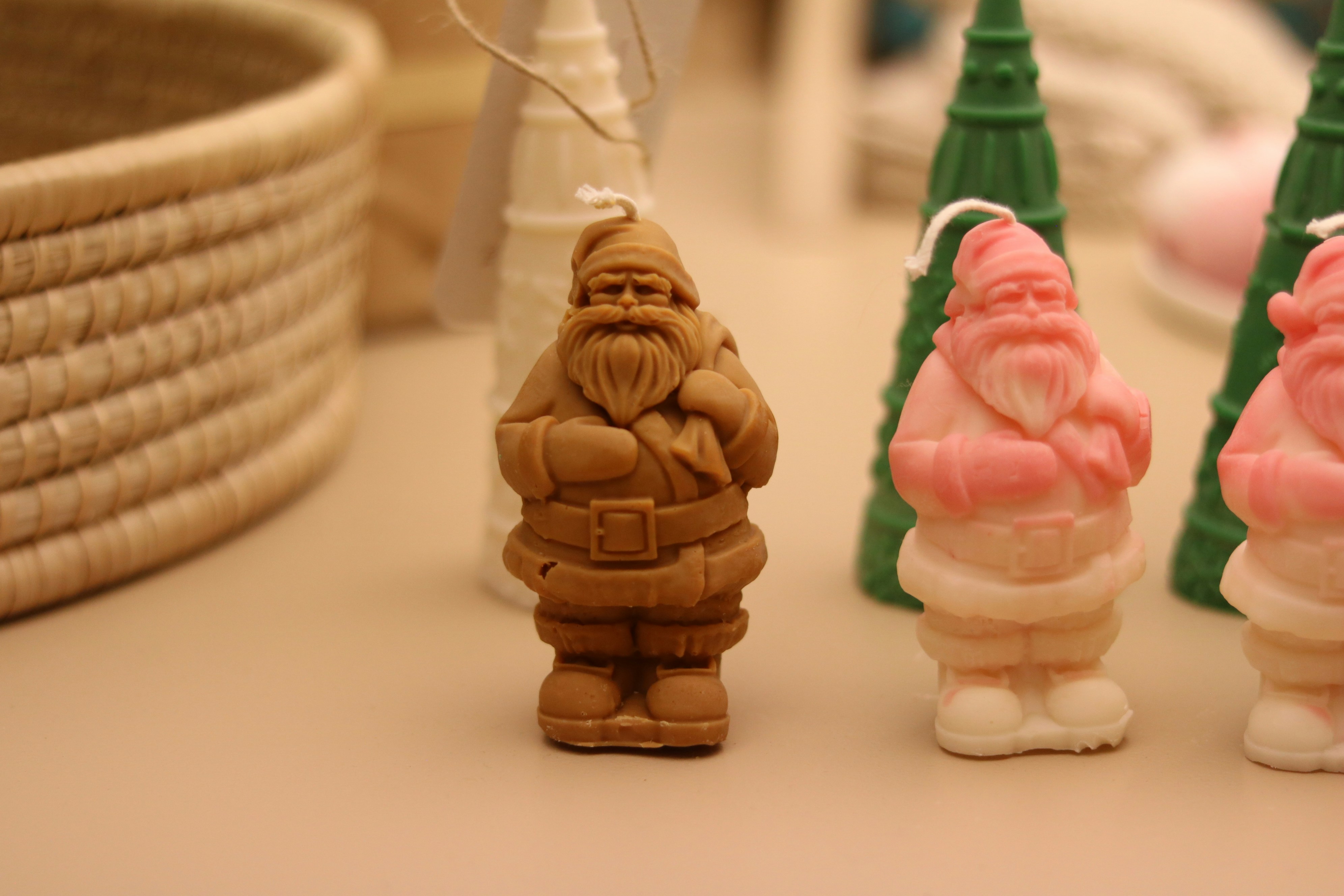 Row of santa claus candles and woven basket