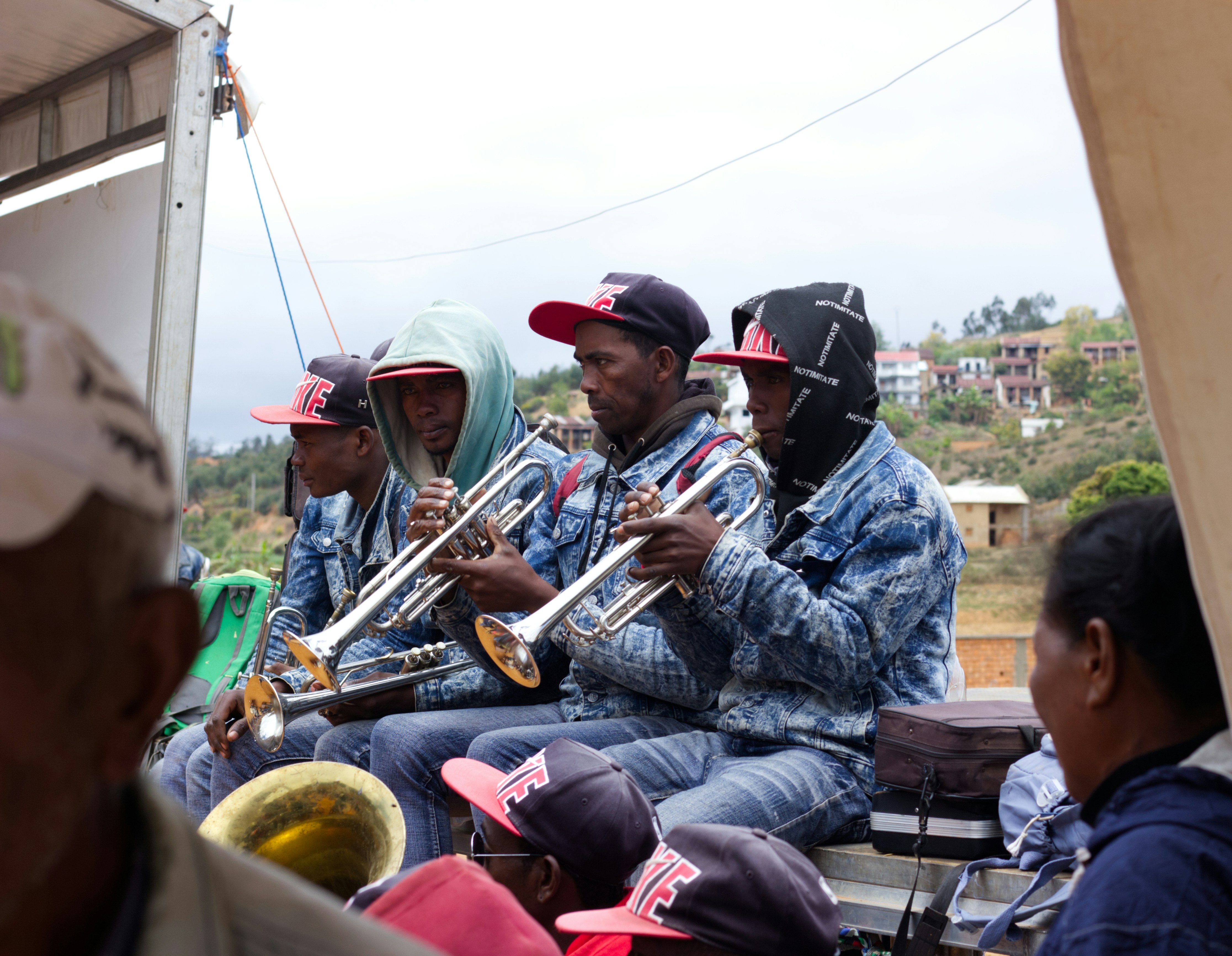 Band members playing trumpets on a vehicle.