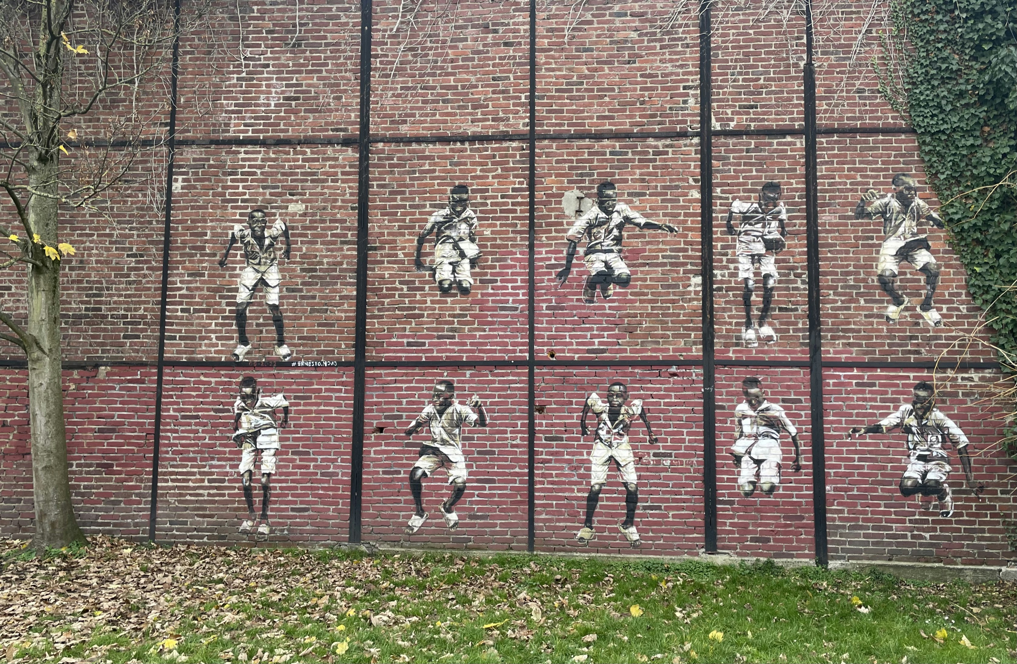 レンガの壁に飛び乗るサッカー選手の落書き