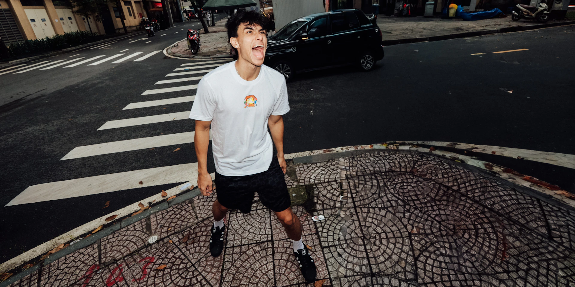 Young man shouting on a city street sidewalk.