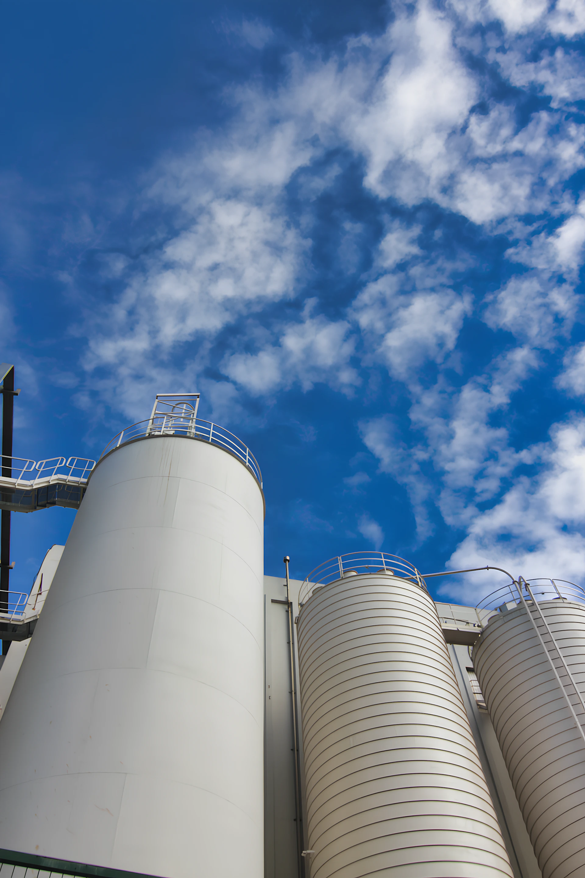 Industrial silos against a bright blue sky